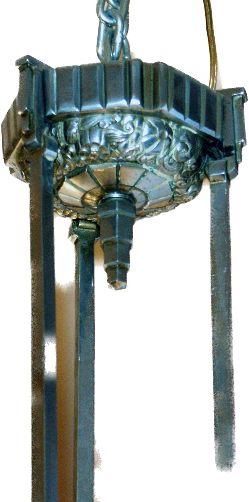Die Leuchte stammt aus der Mitte des 20. Jahrhunderts und besteht aus einer weiß verchromten Bronzestruktur, die drei tulpenförmige Lampenschirme trägt. Die Lampenschirme und das einteilige Mittelbecken sind aus geformtem und gepresstem Glas, einer