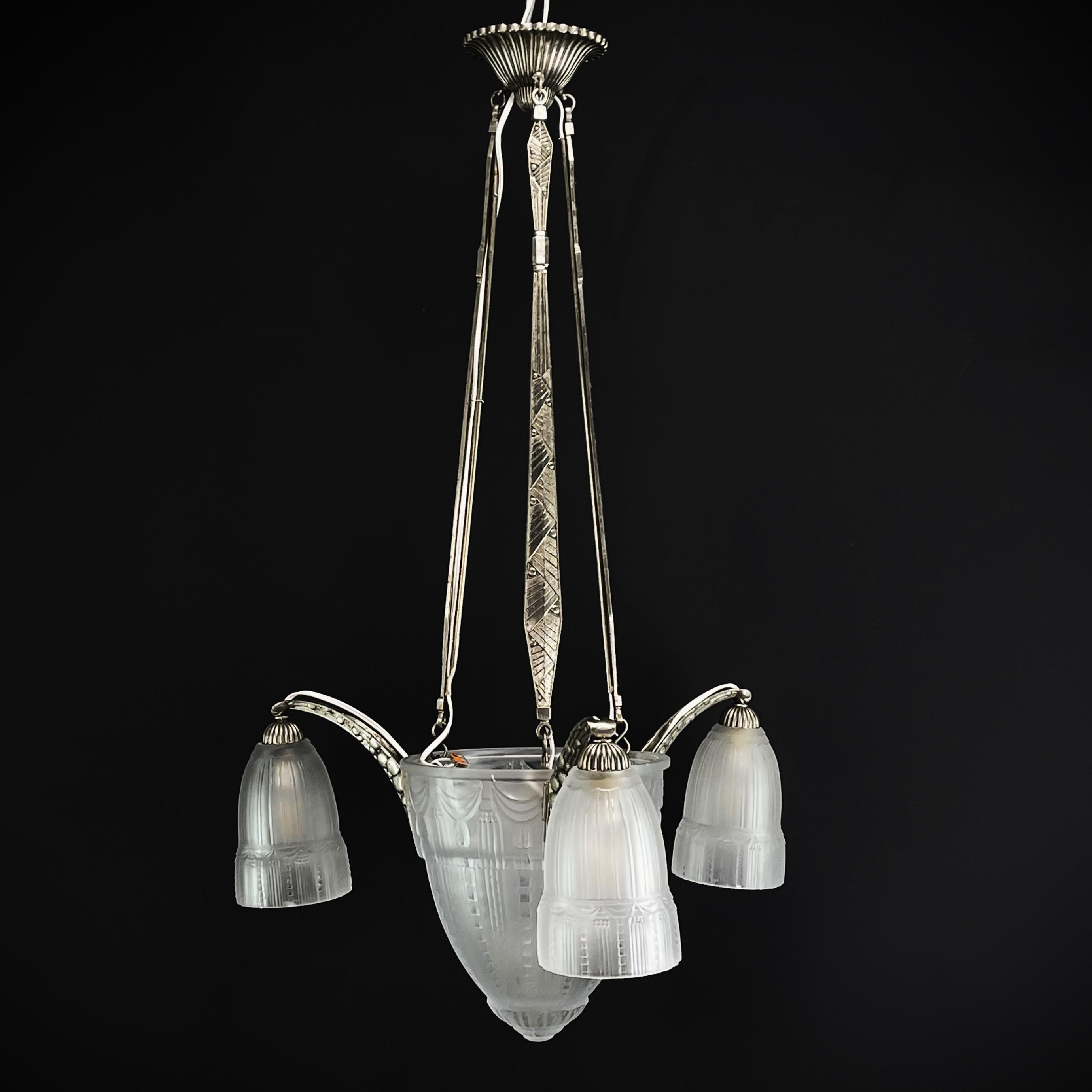Art Deco chandeliers by Muller Frerés Luneville

This stunning Art Deco chandelier from the 1930s is an outstanding example of the elegance and sophistication of the Art Deco style. With its combination of nickel-plated bronze and glass, this