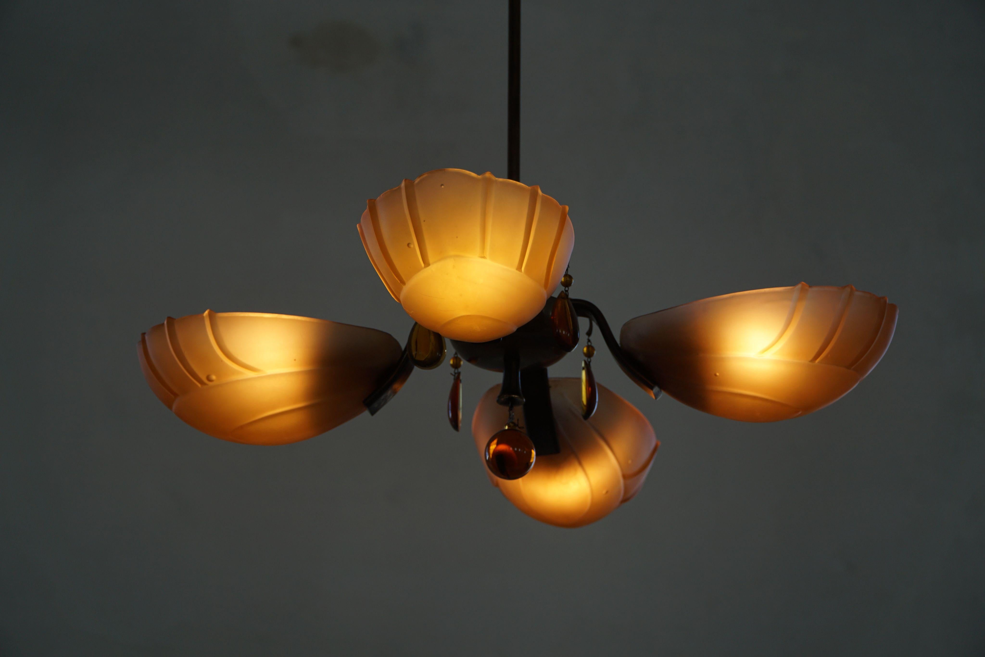 Eine seltene Pendel-Deckenleuchte aus den 1930er Jahren von Paavo Tynell für Oy Taito, die die frühe Meisterschaft des Designers in Bezug auf Form, MATERIAL und Licht verdeutlicht. Der elegante Rahmen aus patiniertem Messing trägt vier zart
