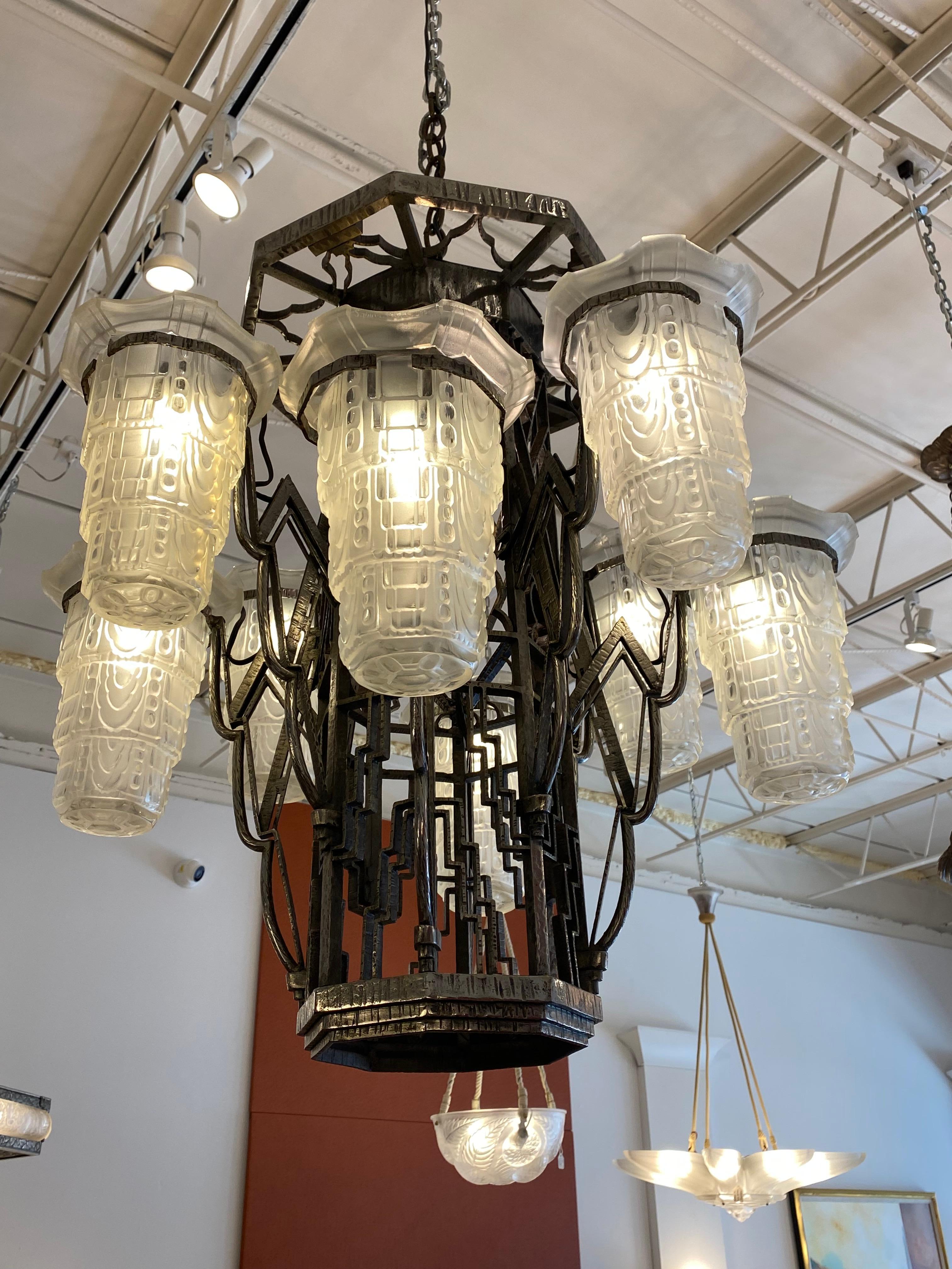 A French Art Deco wrought iron chandelier with frosted glass shades by Ernest-Marius Sabino.
Signature: Sabino on the glass shades

