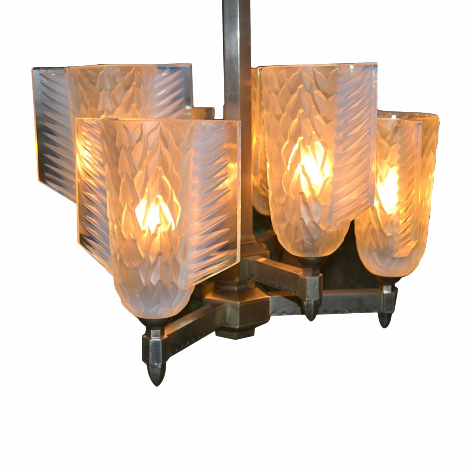 A period French Art deco chandelier; the silvered bronze frame holding two tiers of lighting; each tier has three thickly cast opalescent shades in the shape of a quiver made by Pierre D'Avesn.

Pierre Gire, aka Pierre d'Avesn, was born in 1901. At