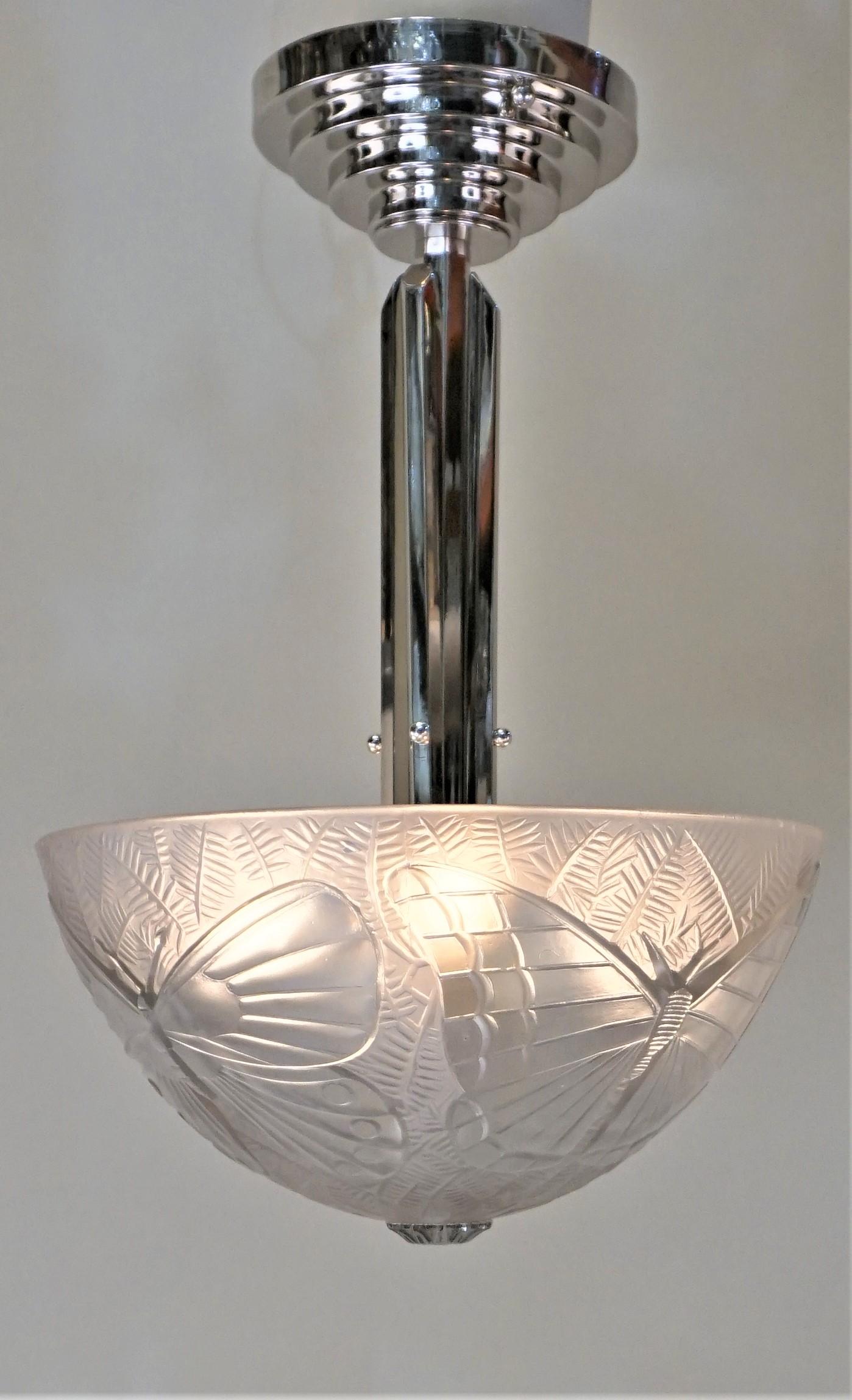 A French Art Deco chandelier by Simonet Freres, in clear and frosted glass large butterflies on four sides molded with nickel on bronze center rod.