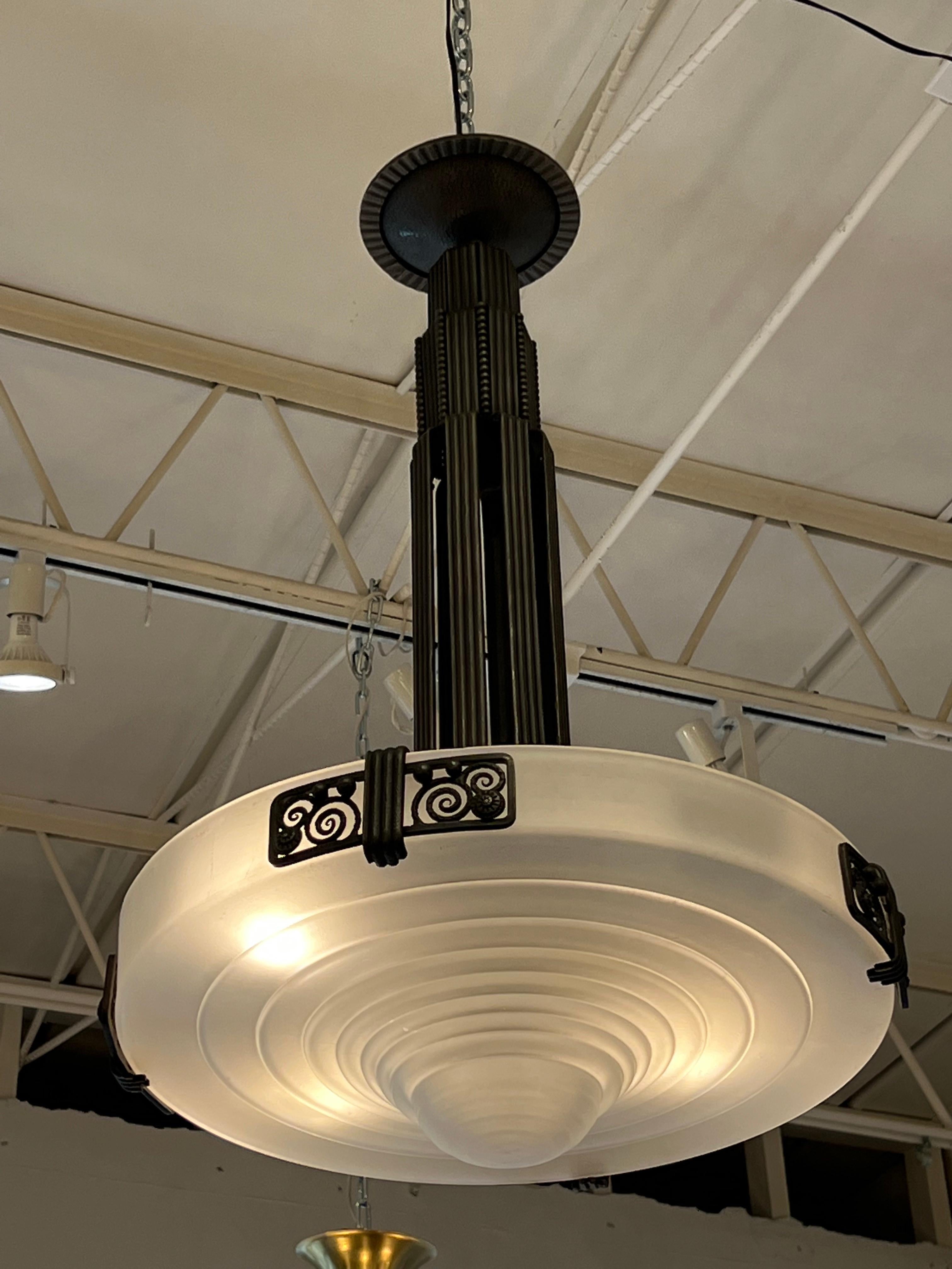 Lampadario Art Deco in ferro battuto con paralume in vetro progettato dalla francese VAG.
Prodotto in Francia.
Circa: 1928.