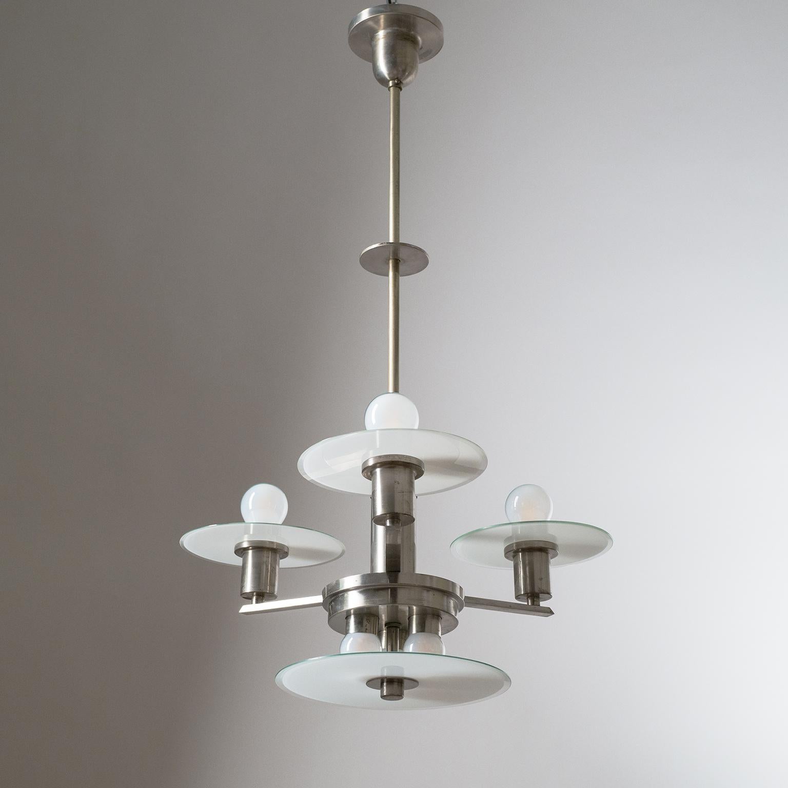 Rare geometric Art Deco or Bauhaus chandelier, circa 1930. Nickeled brass hardware with unusual glass shades, which are clear on one side and have a white casing on the other, along the rim the white casing has been 'shaved' off so that the rims are