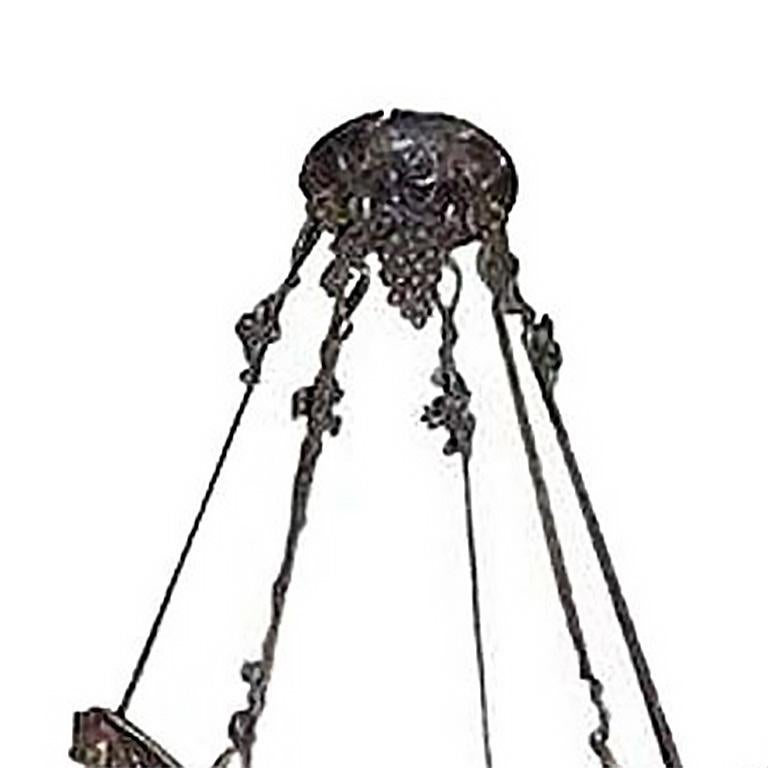 An Art Deco wrought iron and glass chandelier, circa 1930, the central mottled glass bowl within a grape mounted frame hung with six shades.