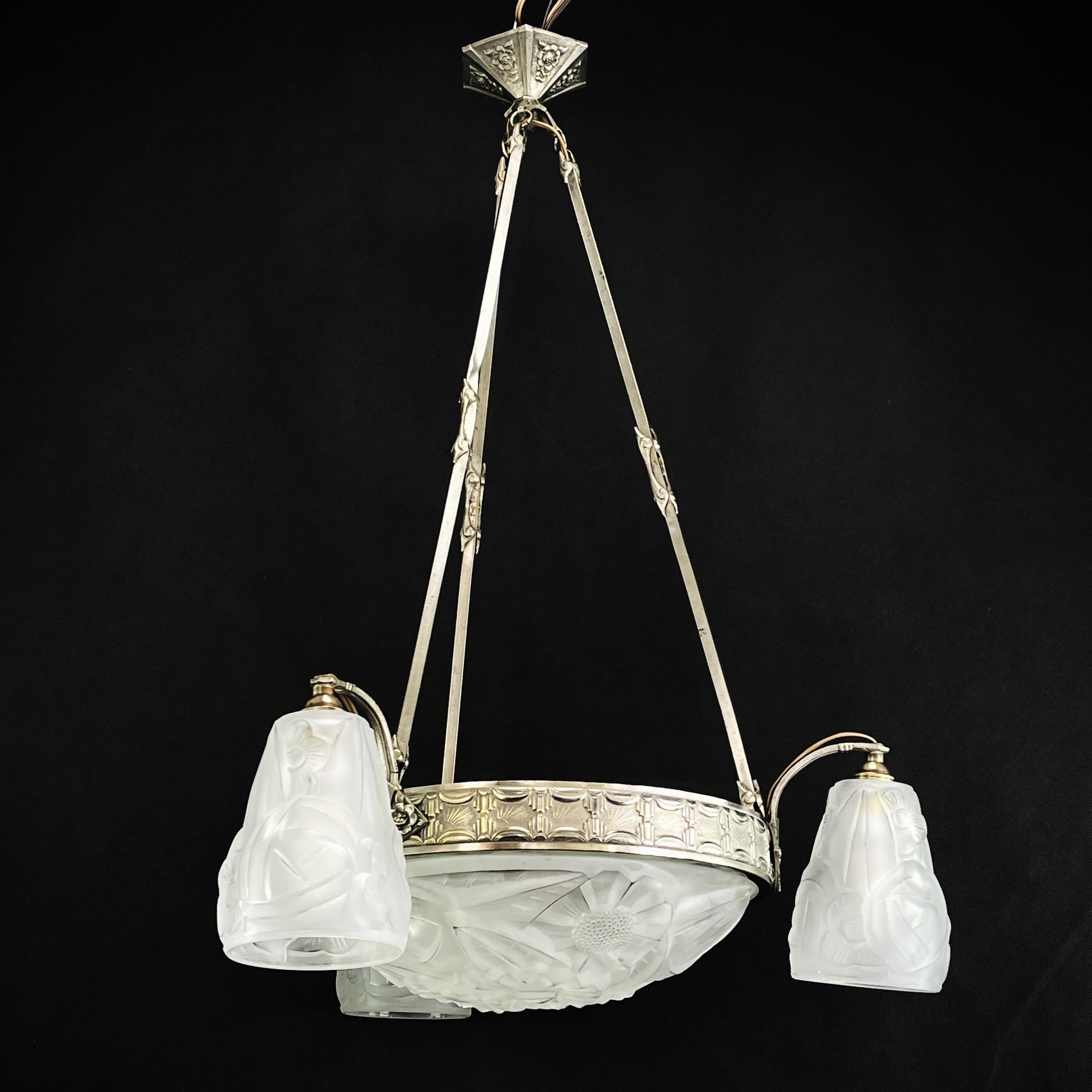 Art Deco Chandelier by Degué

This stunning 1930s Art Deco chandelier is an outstanding example of the elegance and sophistication of the Art Deco style. With its combination of metal and glass, this chandelier embodies the glamor and opulence of