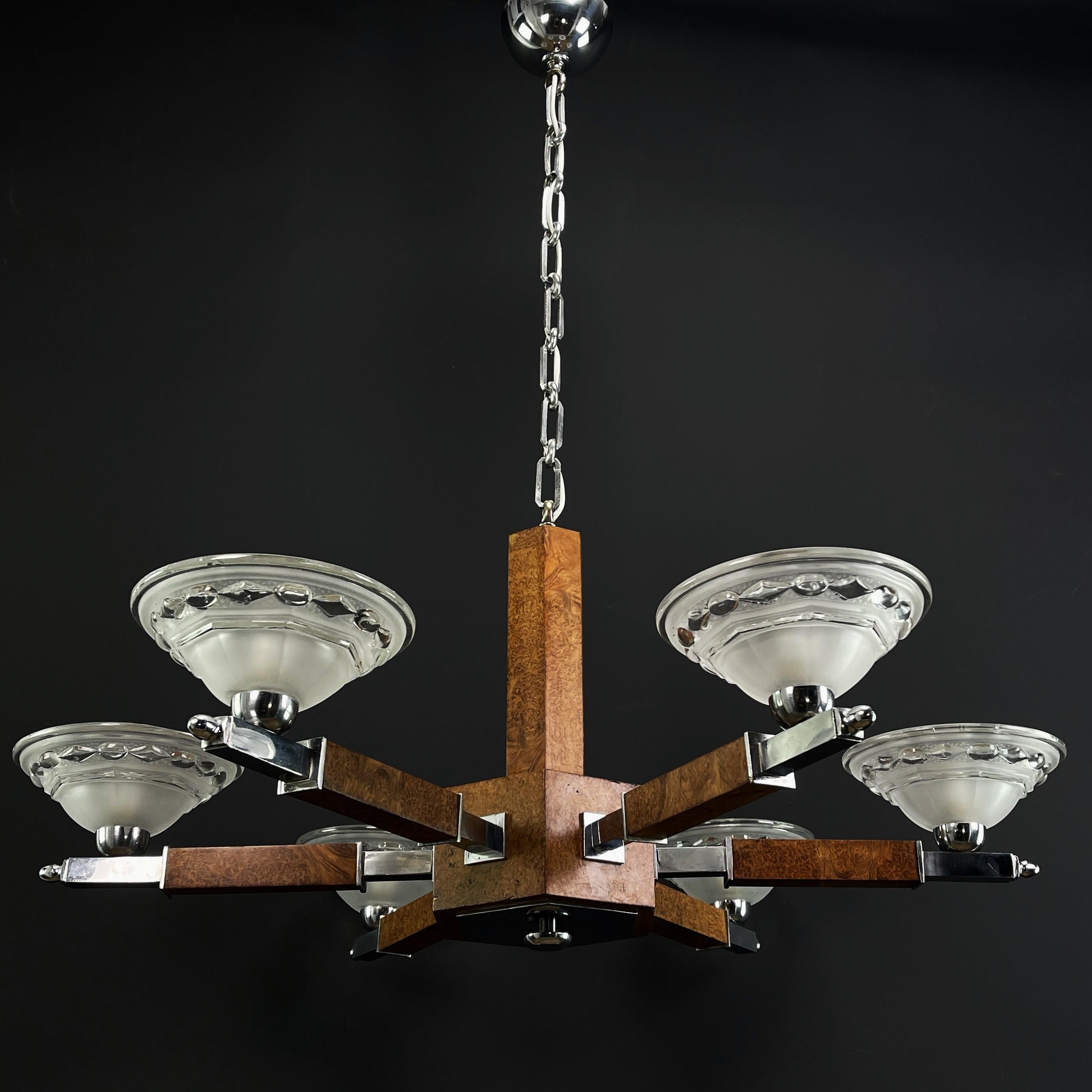 Art Deco chandelier - ceiling lamp wood chrome - 1930s

This stunning Art Deco chandelier from the 1930s is an outstanding example of the elegance and sophistication of the Art Deco style. With its combination of chrome-plated metal, burl wood