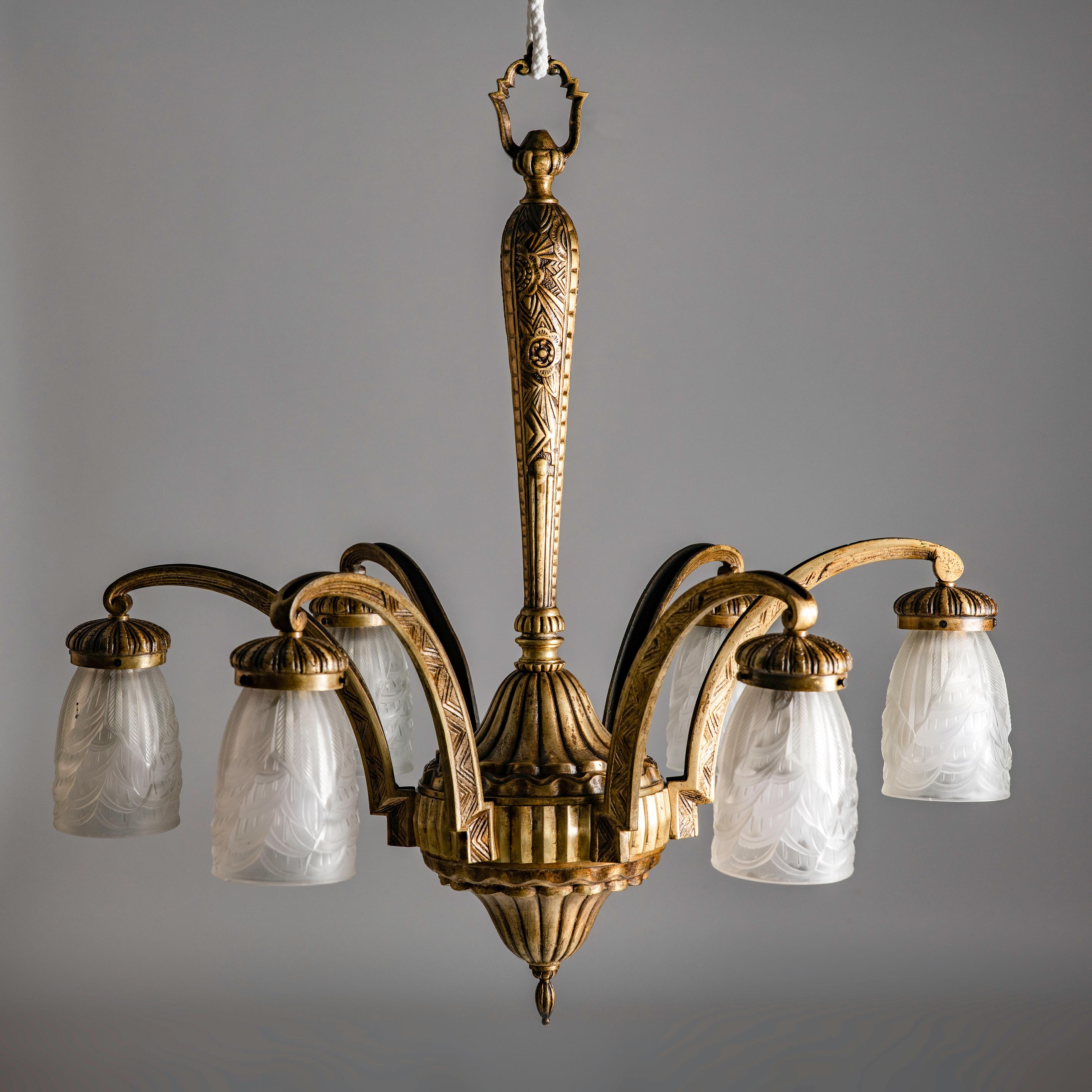 Inmerse yourself in the opulence of the Roaring Twenties with this exquisite Art Deco bronze chandelier by Hettier & Vincent, adorned with the elegance of Charles Schneider shades. A masterful fusion of geometric precision and ornate detailing, the