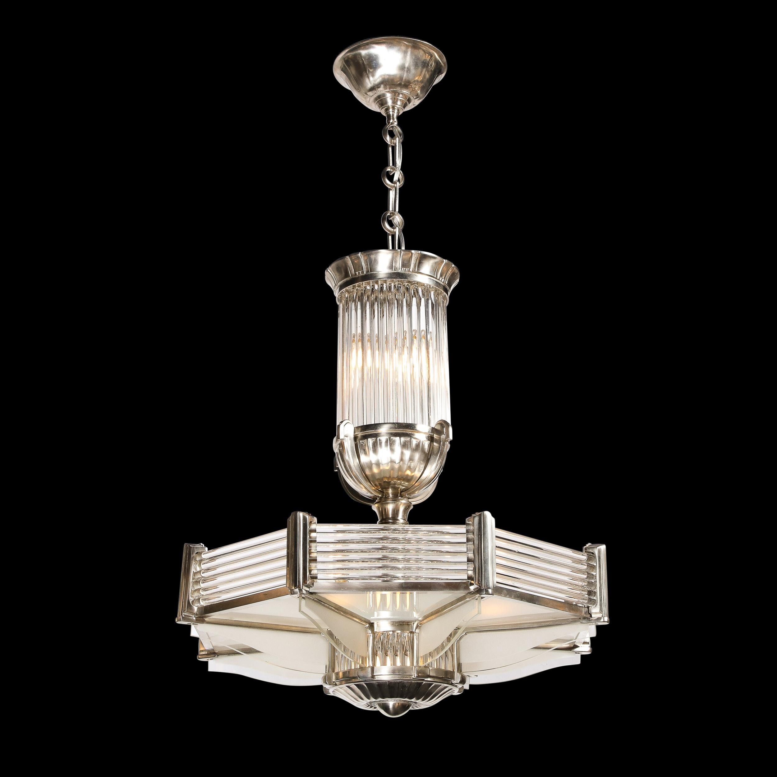 This stunning Art Deco chandelier was realized by the legendary Atelier Petitot in France circa 1930. It features a prominent round channeled finial in satin nickel with a convex protuberant center detail topped with vertical translucent glass rods.