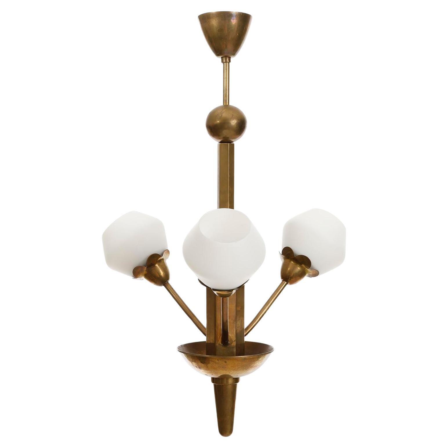 Charmante lampe suspendue à 3 bras de forme organique fabriquée en Suède, vers 1930.
Elle est composée d'une structure en laiton ou en bronze patiné et d'abat-jour en verre opalin.
Chacun des trois bras accueille une douille pour une ampoule à culot