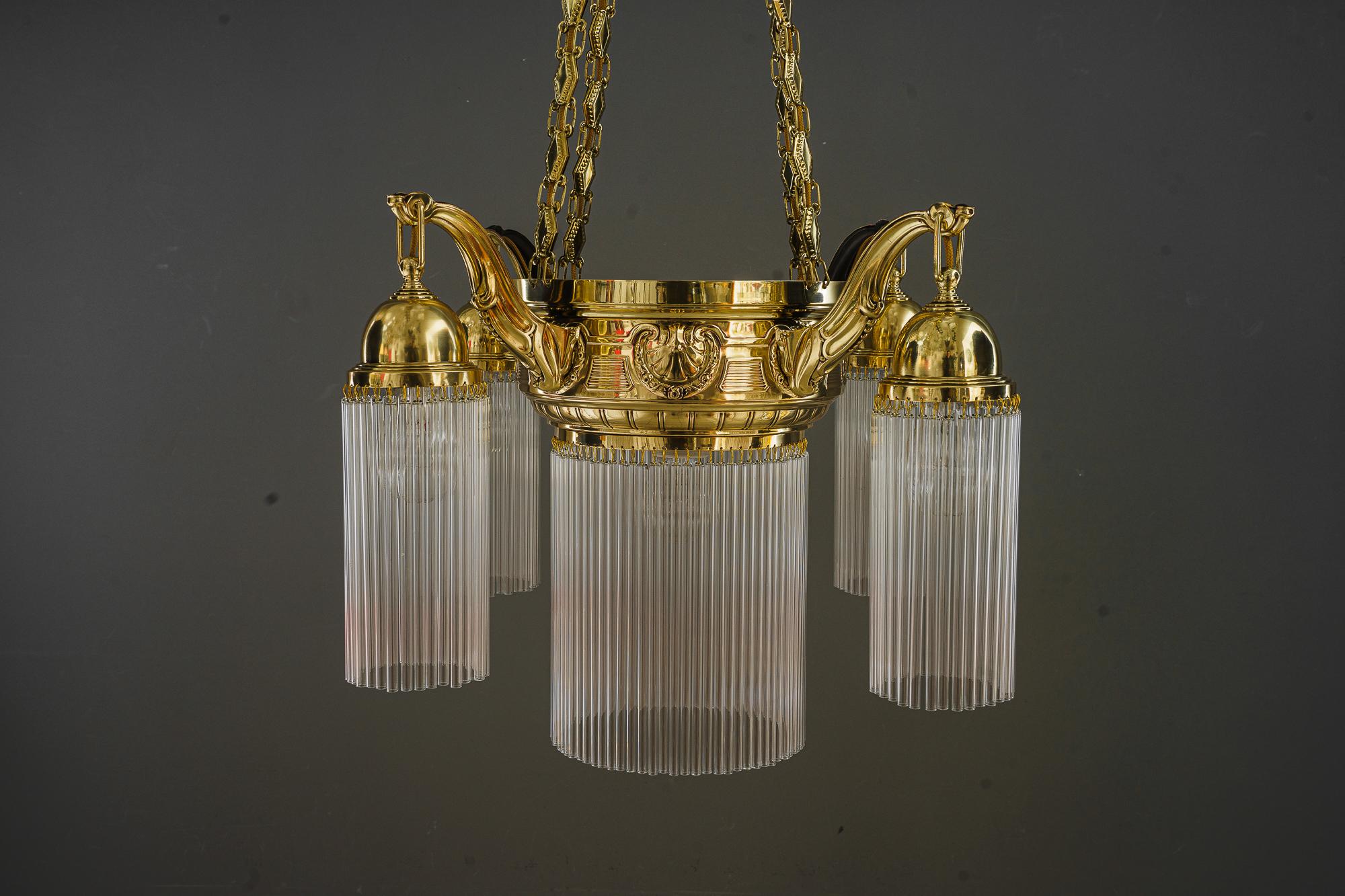 Art Deco chandelier with glass sticks vienna around 1920s 
Brass polished and stove enameled
the glass sticks are replaced ( new )