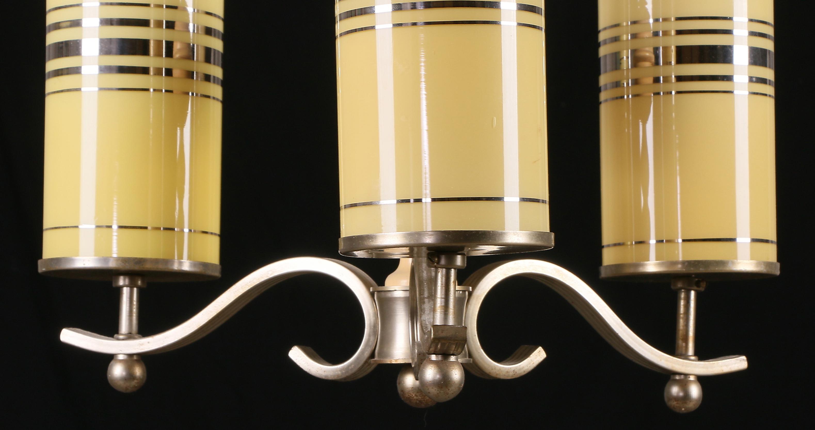 Art Deco chandelier with a nickel-plated brass frame, cylinder-shaped striped glass shades. Manufactured in Denmark in the 1920s. Measures body: height 42, diameter 39 cm, old usage, and friction marks.
The length will be customized on request.
 