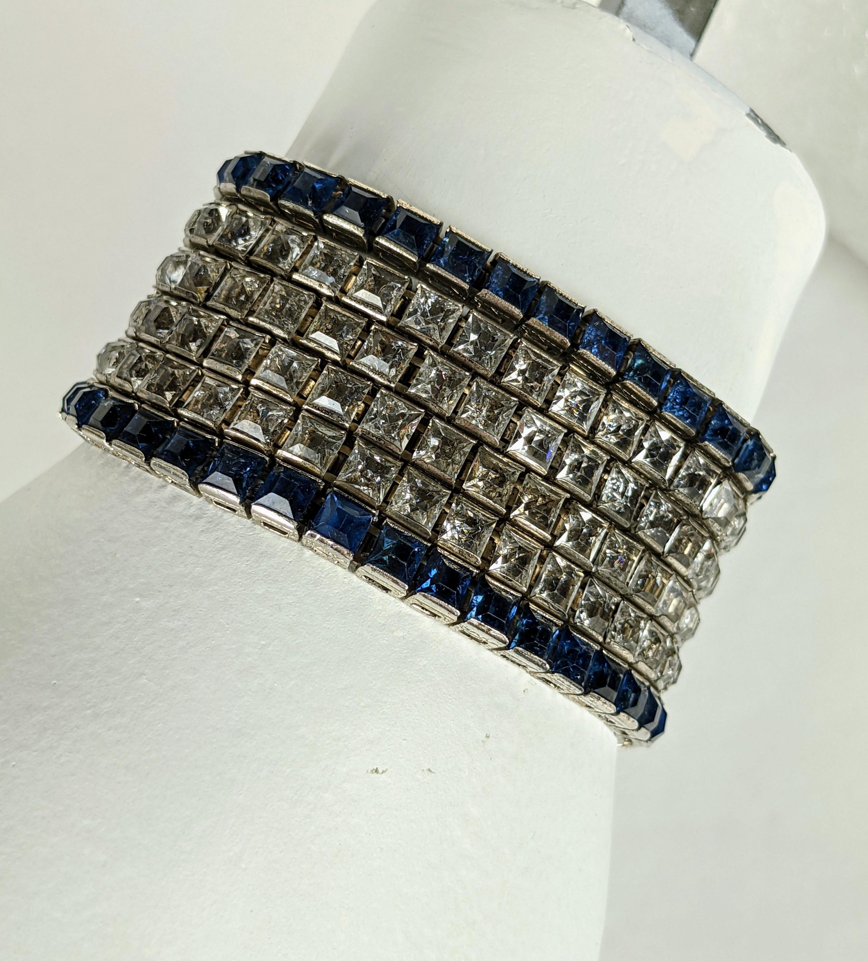 Unusual Art Deco Channel Set Wide Bracelet composed of 6 channel set line bracelets in crystal and dark sapphire crystals joined with an elaborate clasp. Unusual in its width as usually these were worn singly and stacked along wrist. 
Rhodium