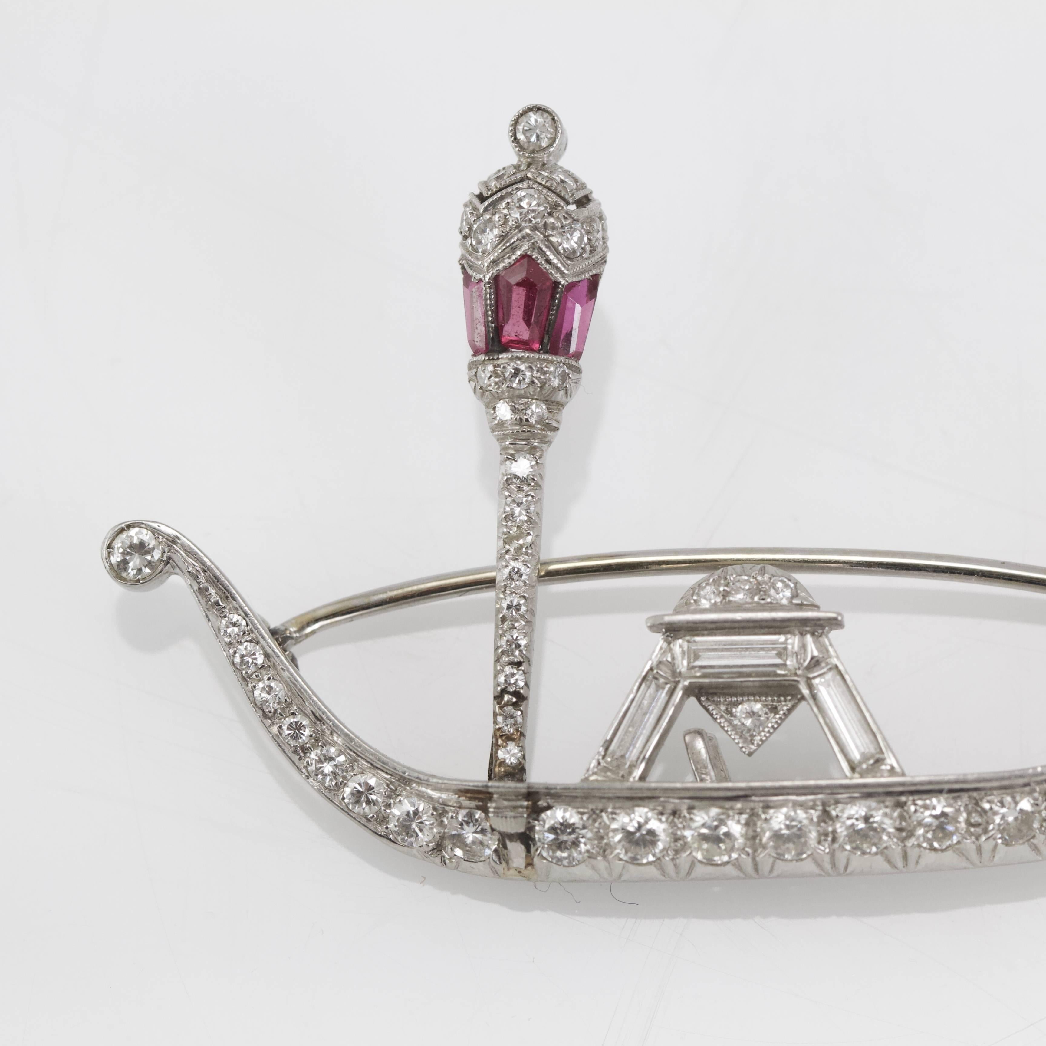 Delicate diamond and ruby brooch shaped as a venitian gondole. 
Set with round and baguette diamonds. Lantern set with three calibré ruby. 
Probably restored at the foot of lantern.  
Made around 1925. 
French recense marks for platinum and gold. 