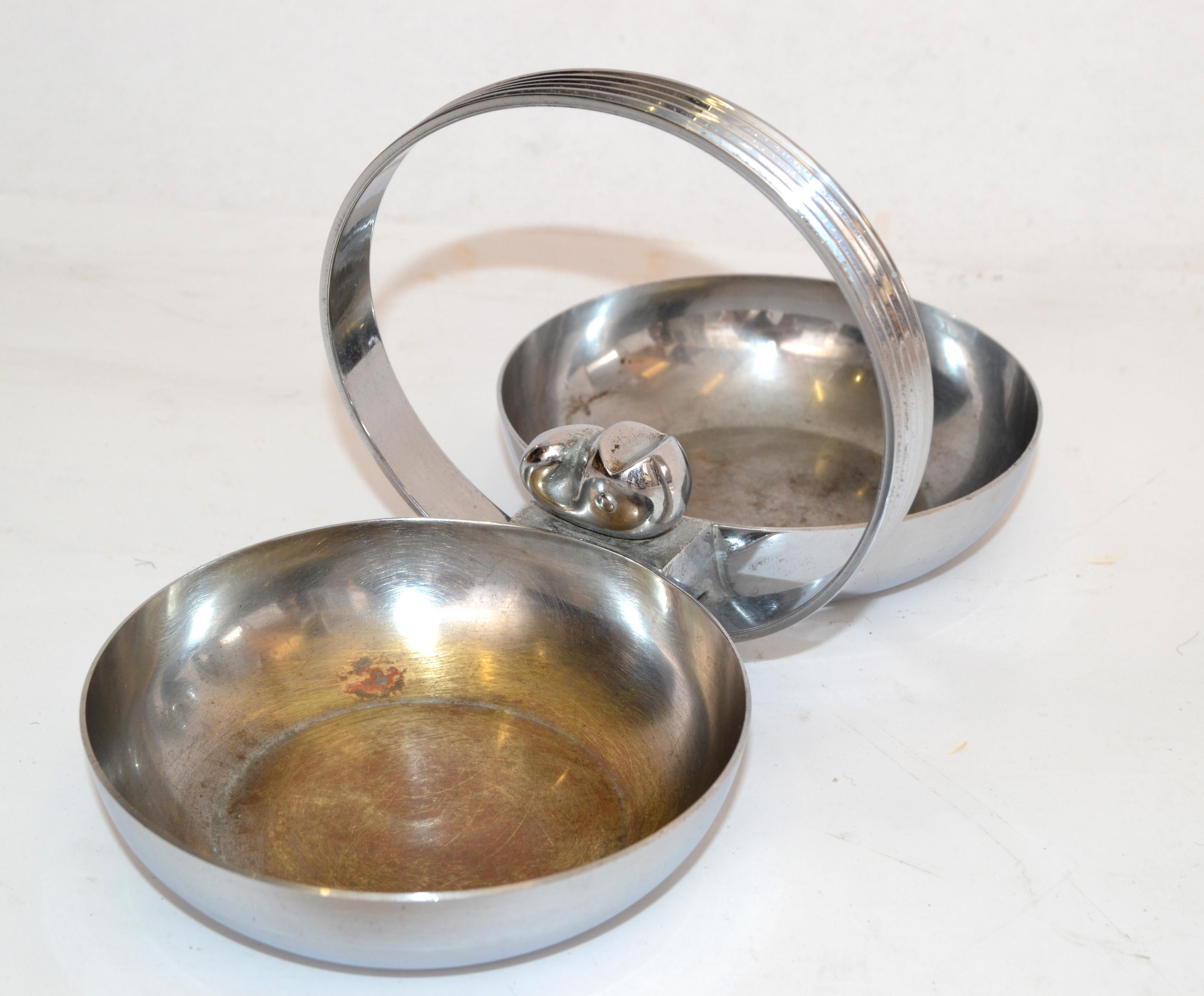 Art Deco Candy and Nut dish features 2 round bowls, decorated by a whale figurine with a hoop handle that is ribbed on both sides, designed by Gerth and Gerth and made by Chase USA. 
The Chrome Plate over solid Brass serving dish measures 8.75