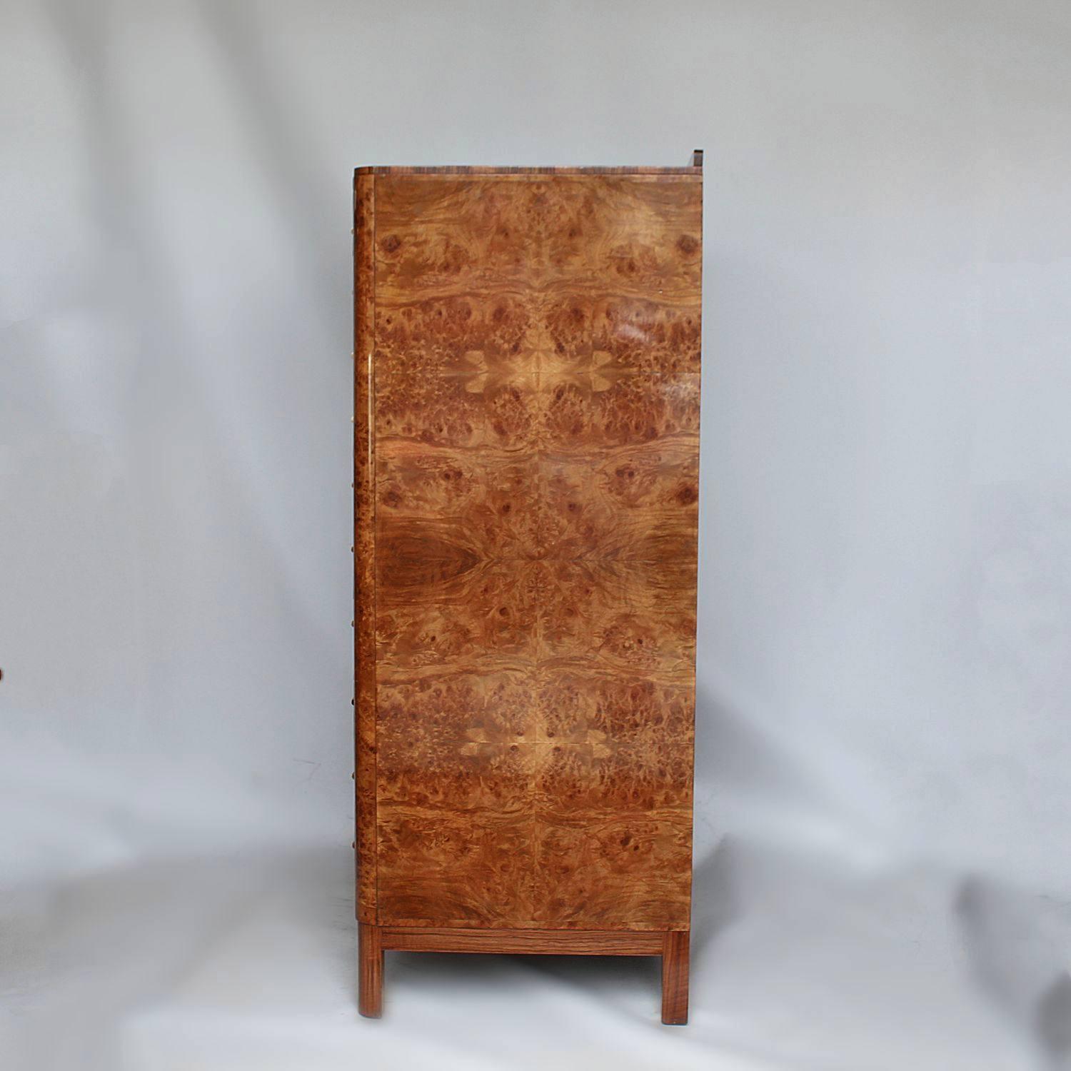 An Art Deco chest of drawers in Burr walnut with walnut fronted drawers and original metal handles. Eight integral drawers with a drop down hidden shelf to bottom.

Dimensions: H 131cm, W 79cm, D 52.5cm.

   