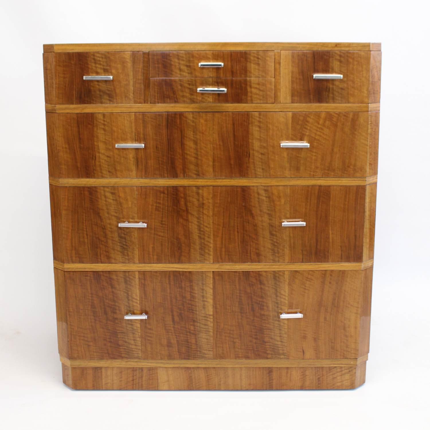 An Art Deco chest of drawers by Heal's of London. Three integral drawers to main body, two small drawers on top centre with two half sized drawers on either side. Straight grain walnut throughout, mahogany lined drawers, and original chrome handles.