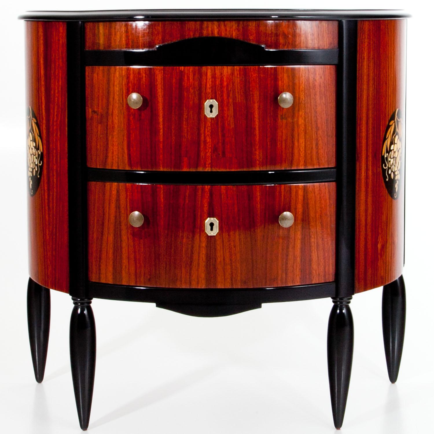 Demilune shaped chest of drawers with conical tapered legs and two drawers. The sides show inlays in the shape of grapes with mother of pearl details. The legs, trusses and top are ebonized.