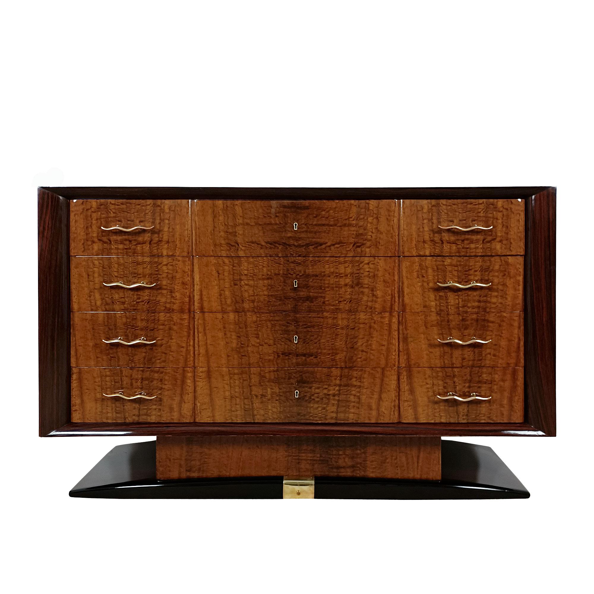 Spectacular large Art Deco chest of drawers in wood with rosewood veneer for the body and base, and burl mahogany for the drawer fronts (made of solid oak) and the foot. French polish. Polished brass handles and base decoration.
Italy circa 1930