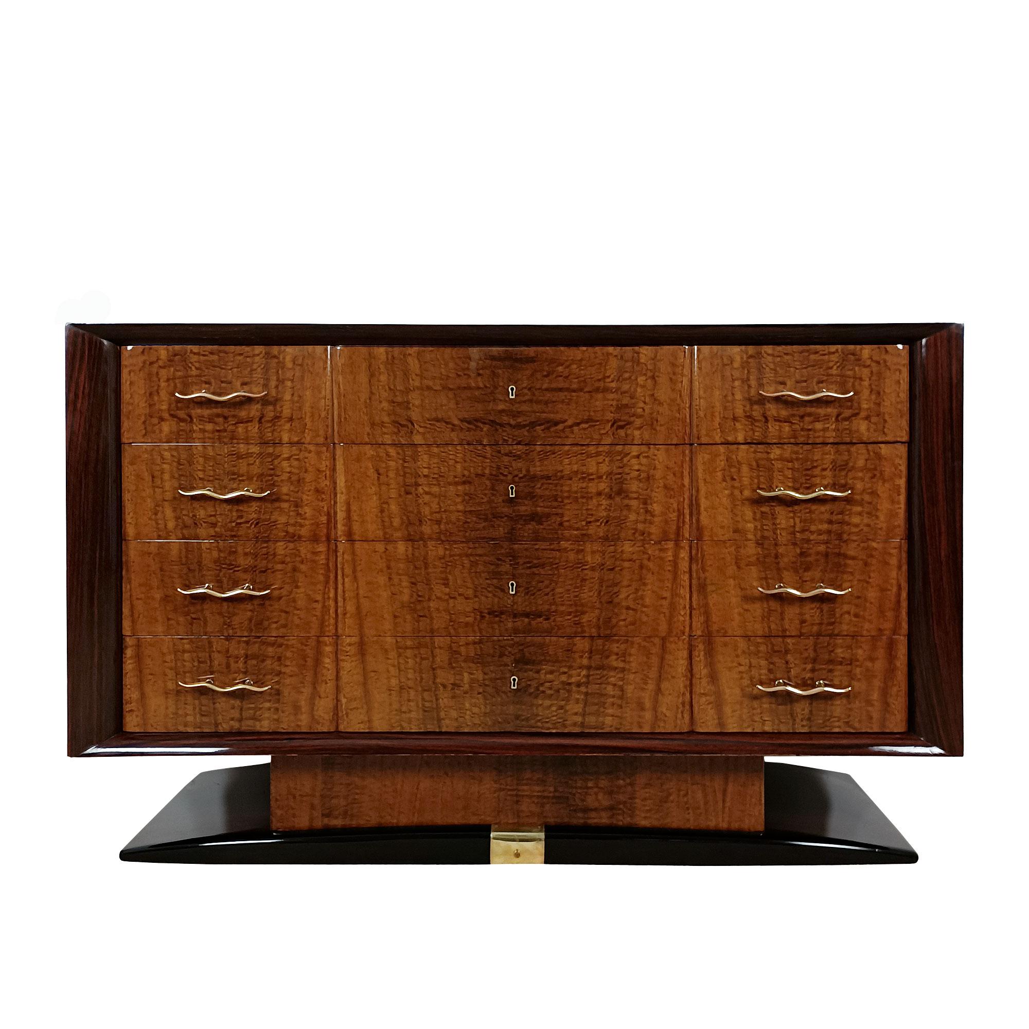 Spettacolare cassettiera Art Déco di grandi dimensioni in legno con impiallacciatura di palissandro per il corpo e la base e radica di mogano per i frontali dei cassetti (in rovere massiccio) e il piede. Smalto francese. Maniglie e decorazione della