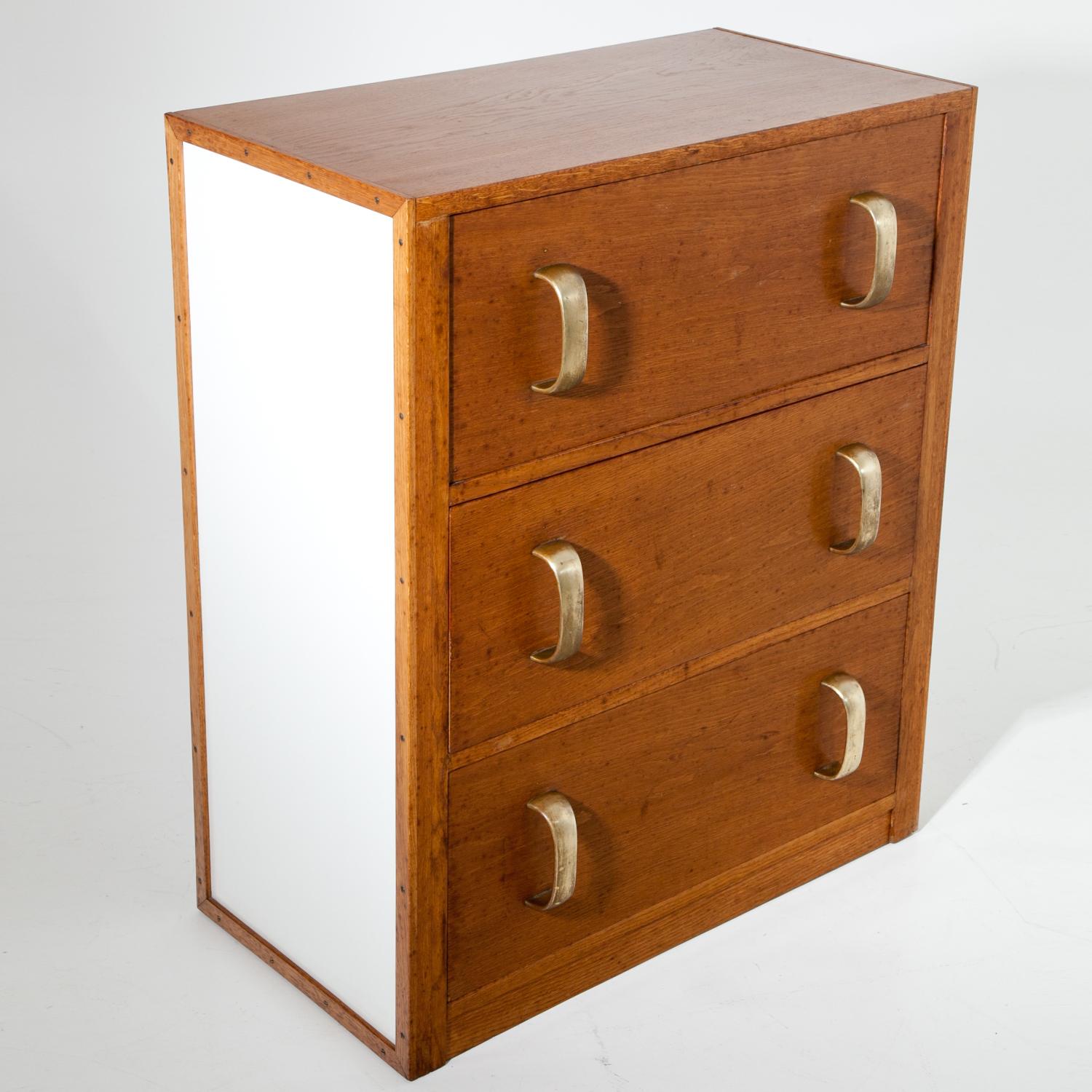 Art Deco chest of drawers with a straight body, white side panels as well as three drawers with smooth brass handles. Viennese manufacturer Herrgesell created similar chests with vertical handles, see MAK Wien, Inv. No. KI 15765-3064-74 and KI