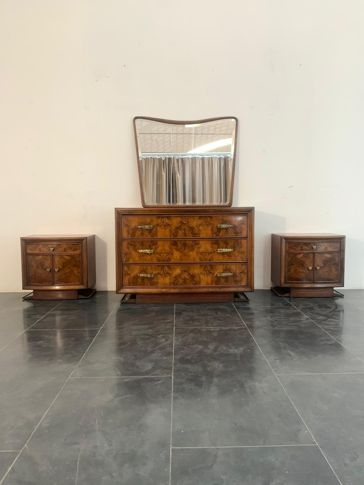 Set di 4: Specchio, cassettiera e 2 comodini di Premuda Mobili, Lissone.
Questo design è un'interpretazione esemplare dello stile Art Deco.
La base grissinata sostiene il corpo leggermente curvo in noce e radica di noce. Il frontale presenta cornici