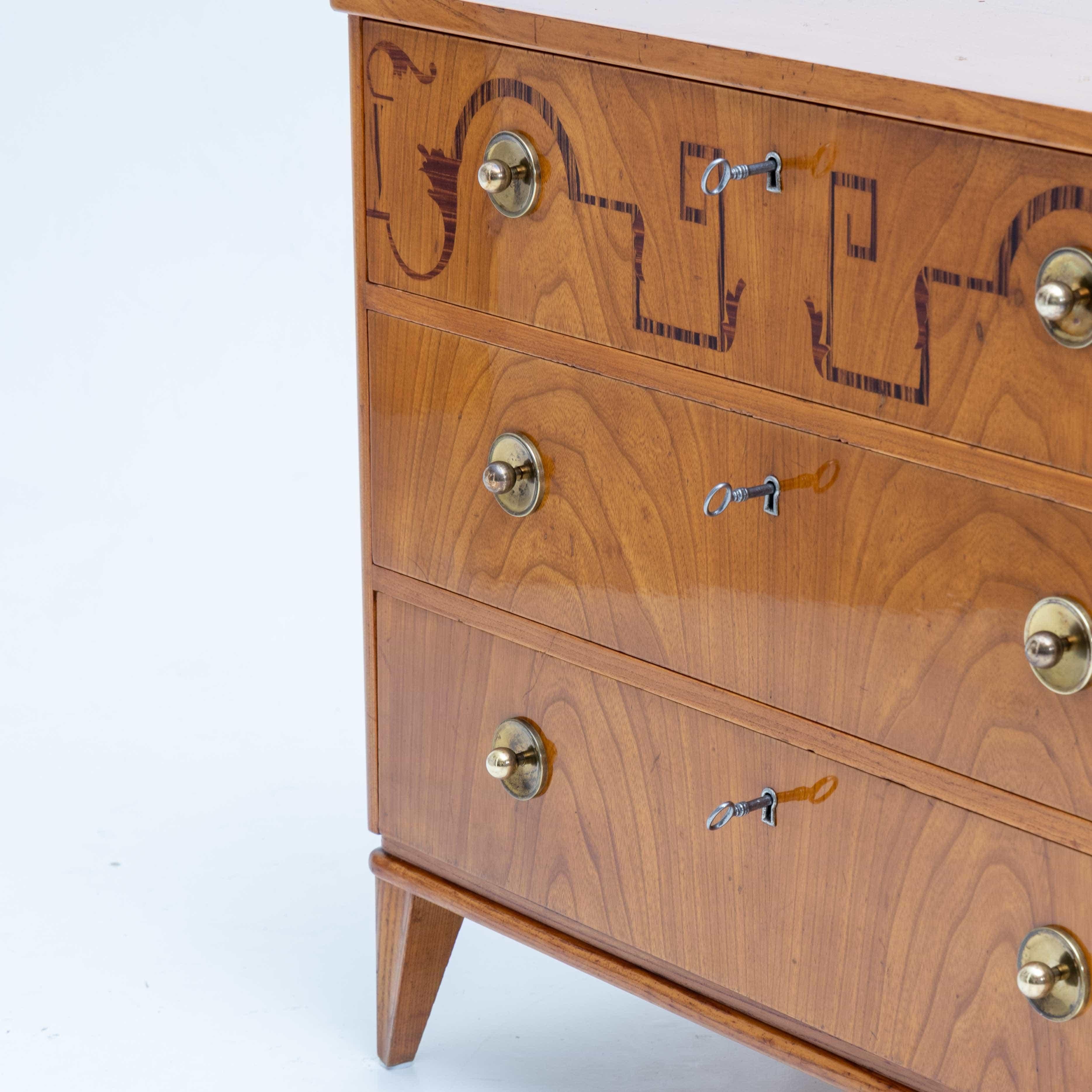 Small Art Deco chest of drawers with brass knobs and three drawers. The top drawer is decorated with inlays.