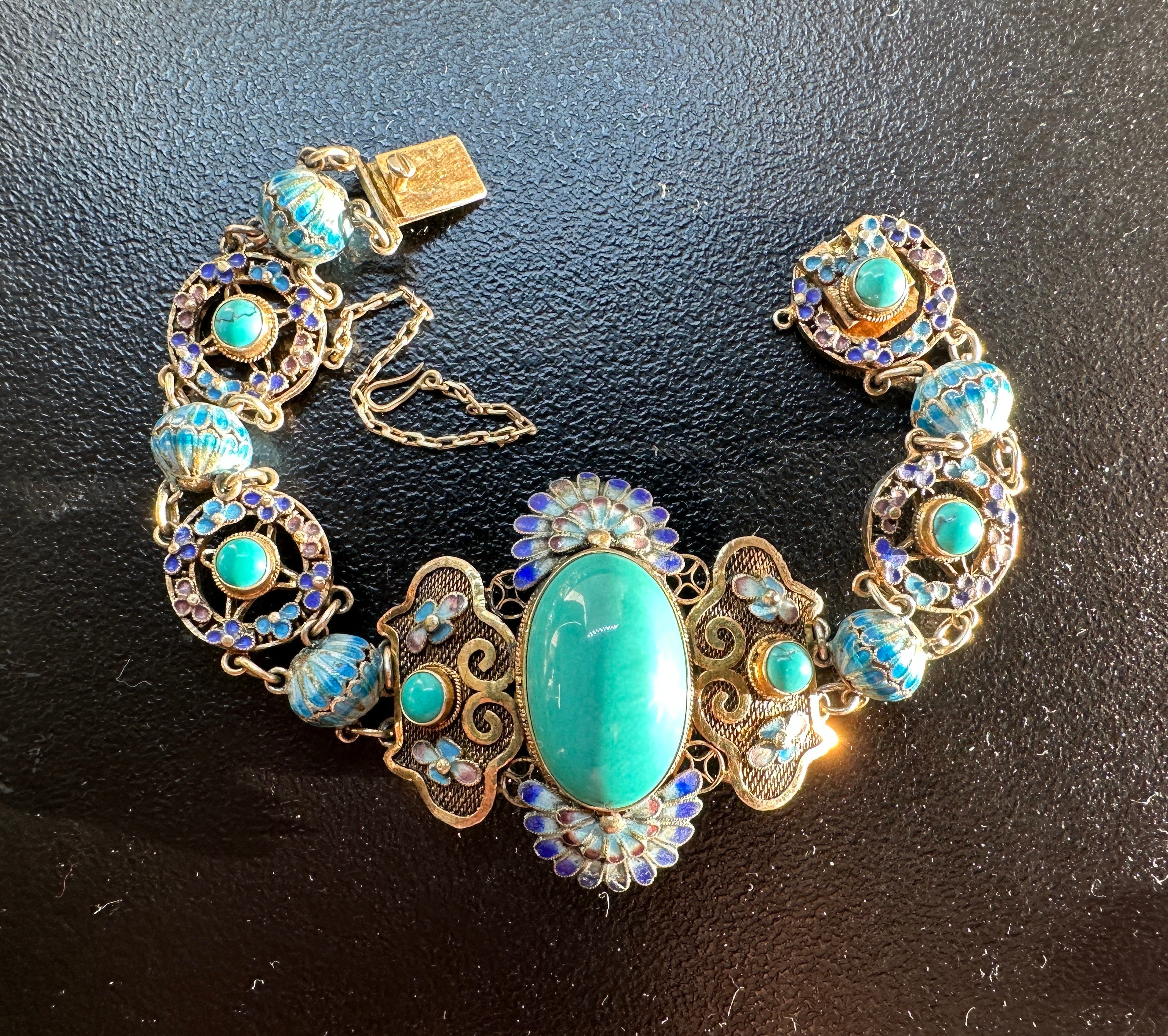CONCEDITI UN ANTICO BRACCIALETTO D'ESPORTAZIONE CINESE IN STILE ART DECO - ART NOUVEAU CON SPLENDIDI CABOCHON DI TURCHESE NATURALE IN UNA MERAVIGLIOSA CORNICE CON MOTIVO A FIORE DI LOTO E SQUISITE DECORAZIONI IN SMALTO IN ARGENTO DORATO.
L'effetto