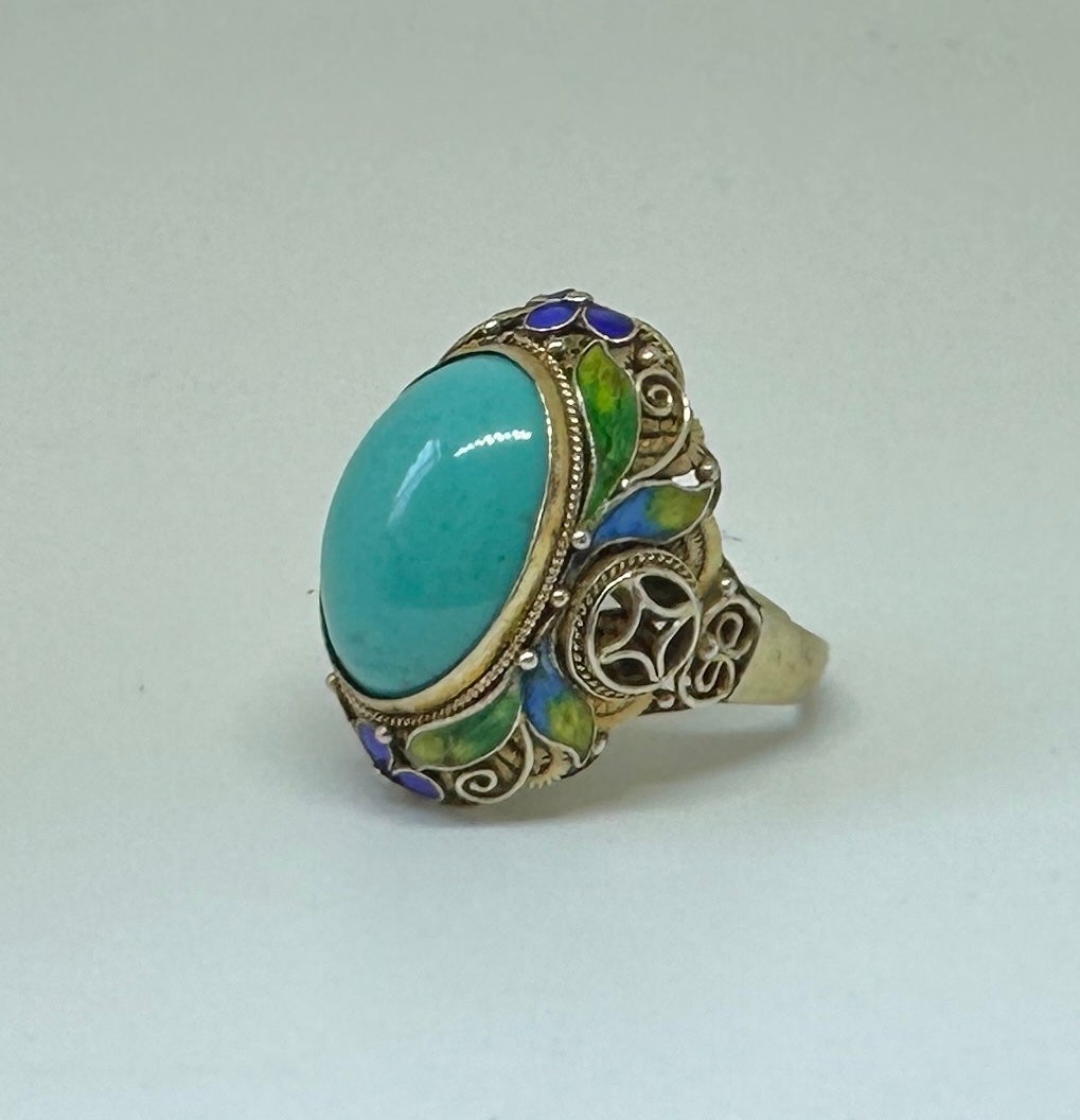 THIS IS AN ANTIQUE ART DECO - ART NOUVEAU CHINESE EXPORT RING WITH A GORGEOUS NATURAL UNTREATED TURQUOISE CABOCHON IN A WONDERFUL FLOWER MOTIF SETTING WITH EXQUISITE ENAMEL DECORATION IN SILVER GILT.
The stunning effect of the gorgeous natural