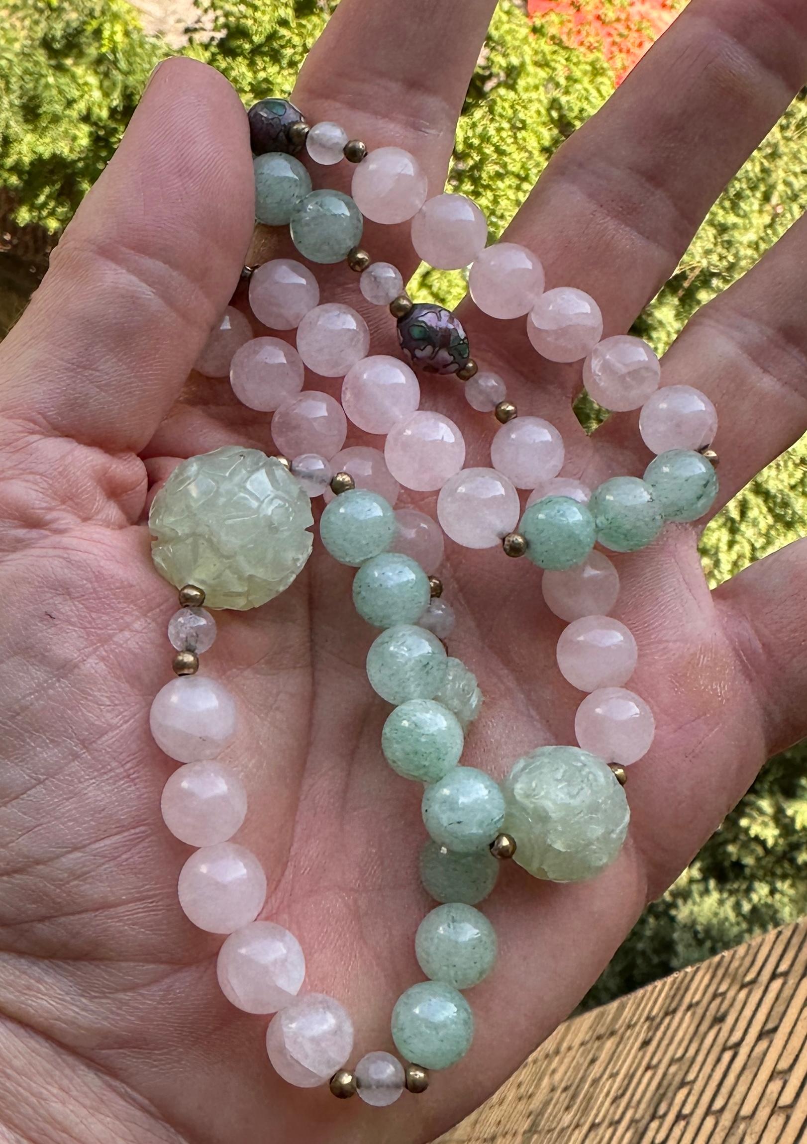 Si tratta di una spettacolare collana di perle di quarzo verde e rosa dell'Art Déco cinese.  La favolosa collana è lunga 36 pollici.  Ha perline di quarzo verde intagliate a mano con motivi floreali e perline di porcellana con ornamenti floreali. 