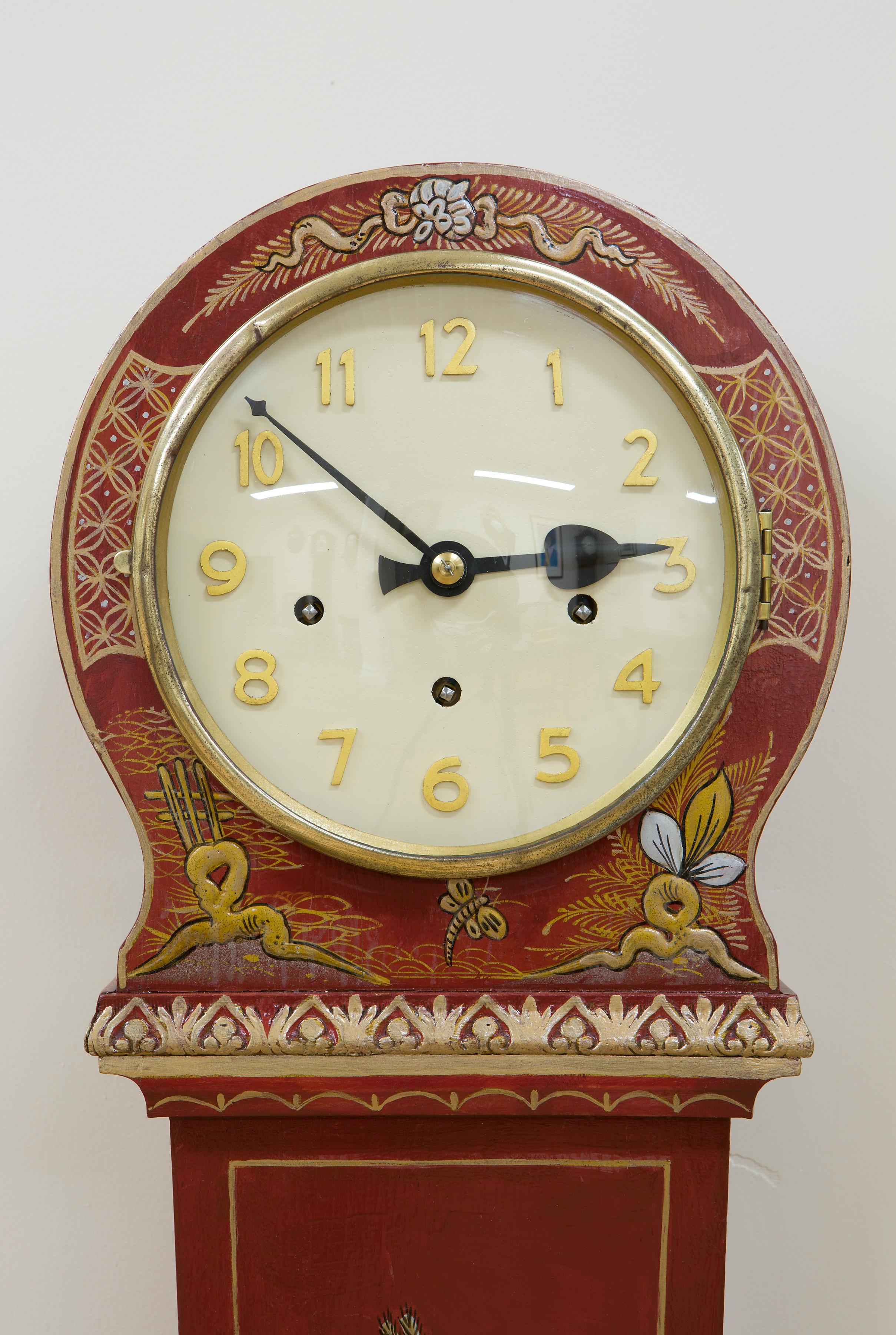 Art Deco grandmother clock in a tapered case with Chinoiserie decoration on a red ground.

Painted dial with raised Arabic numerals.

Eight day Westminster quarter chiming movement, circa 1925

 
