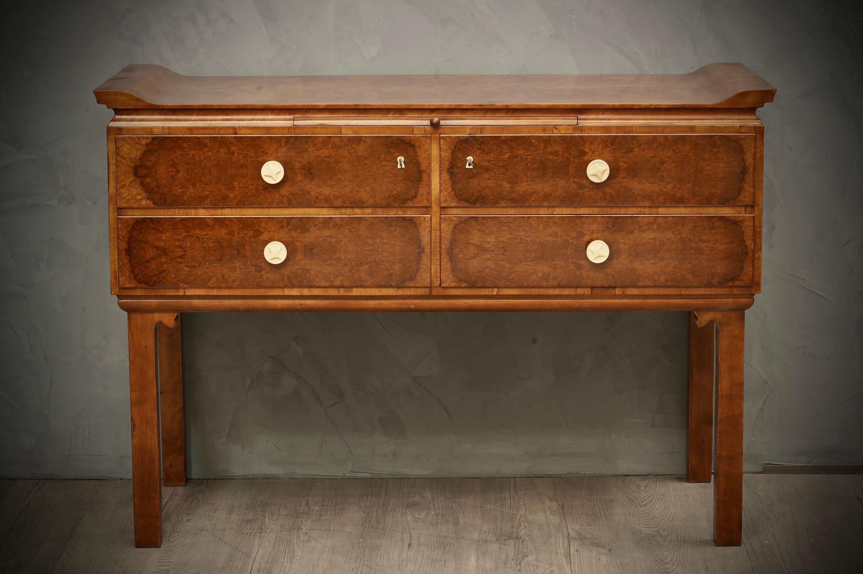 Austrian Art Deco chest of drawers. Chinoiserie by the very particular design.

All veneered in walnut wood, with four drawers. The top of the dresser is flat but has two movements on the sides of the dresser top. On the front, the four drawers are