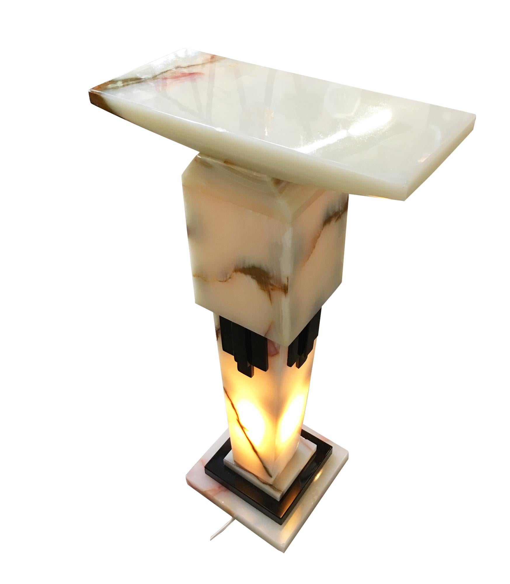 Fine quality re-edition marble and bronze pedestal in the style of Chiparus featuring a white onyx marble pedestal with black marble accents with a stepped design. Front and center of the stand is a plaque applique made of bronze with two nude