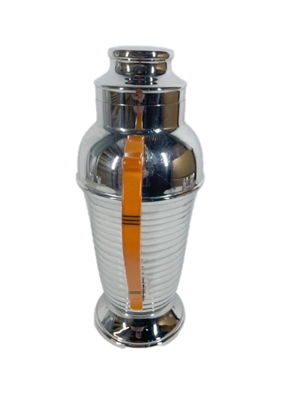 Art-Deco-Cocktailshaker-Set aus Chrom und Bakelit, bestehend aus einem urnförmigen Shaker und vier Cocktailgläsern mit Stiel. Der Shaker hat einen Griff aus Bakelit mit geschwärzten, eingeritzten Linien und einen gerippten Körper, die Gläser mit