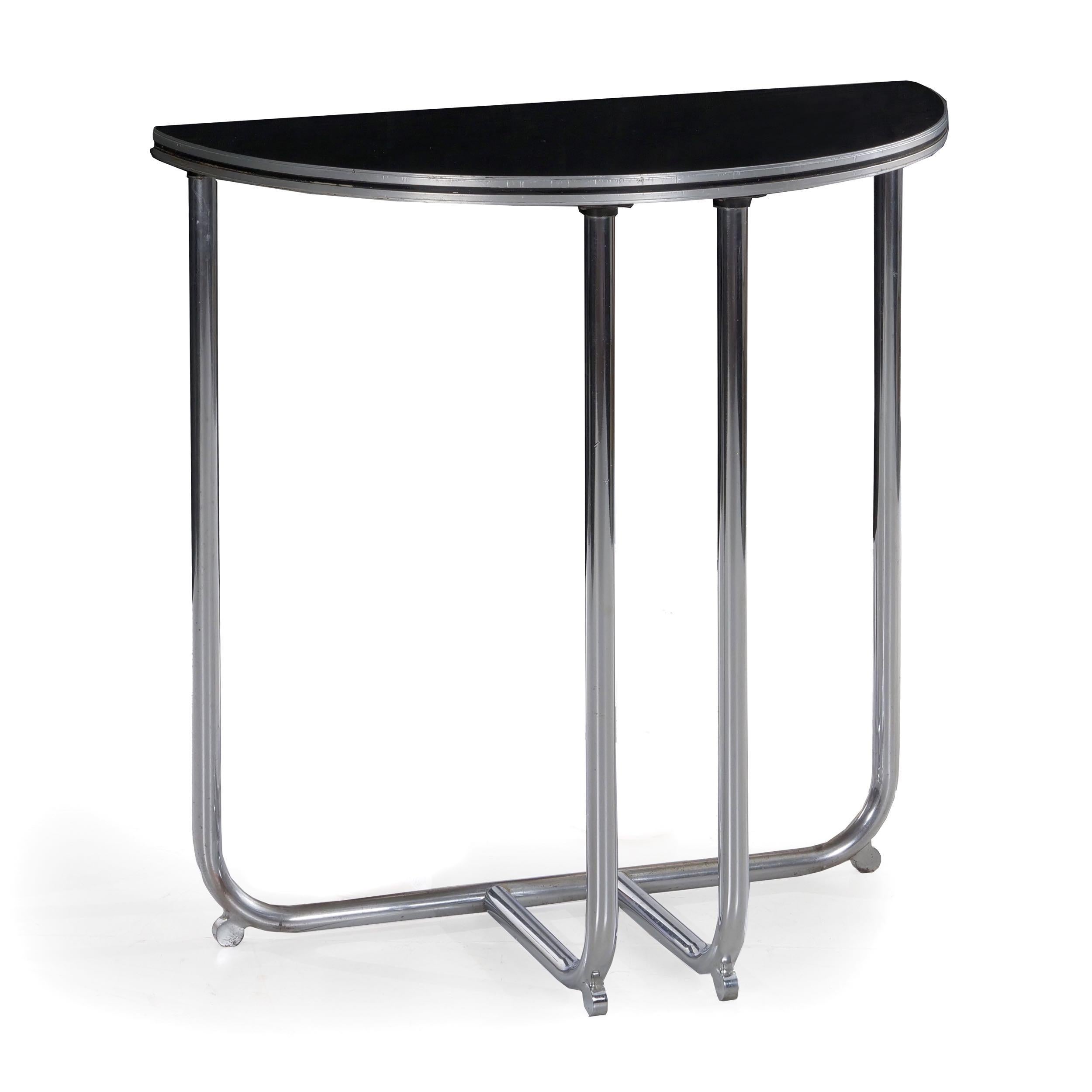 A machine age creation manufactured by Royalchrome in the manner of Wolfgang Hoffman, Donald Deskey and the other luminaries of the Streamline Moderne movement, this gorgeous demilune console table is crafted of bent tubular steel with small round