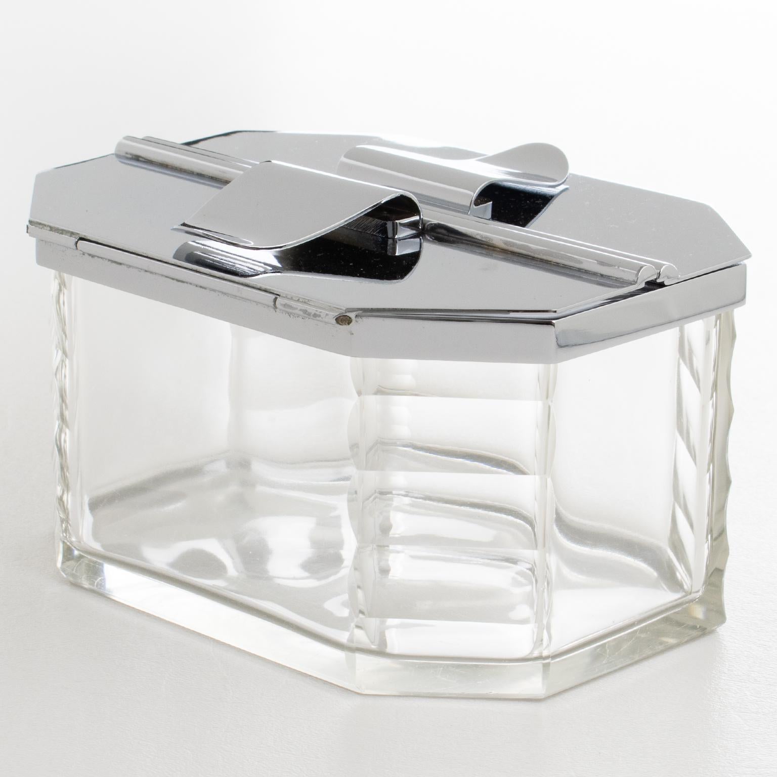 El orfebre francés Francois Frionnet, de París, diseñó y fabricó esta impresionante caja decorativa Art Déco de cromo y cristal para galletas hacia 1930. El diseño modernista y minimalista presenta un recipiente geométrico de cristal y soplado a
