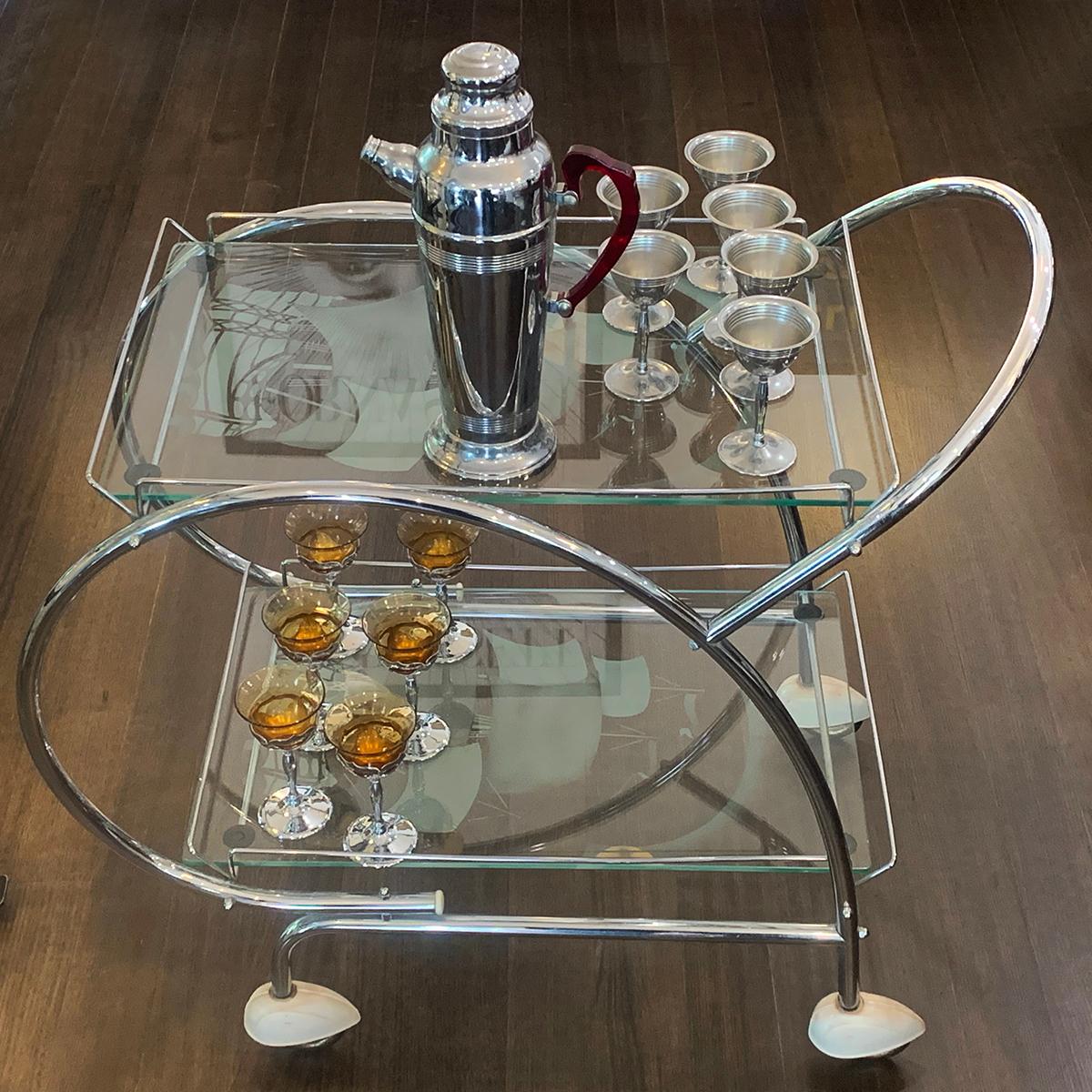 Spectacular, original Art Deco bar cart in Chrome with etched galleons on both glass shelves. Amazing original condition with a soft aged patina to chrome, and no wear to black rubber tyres. Negligible minor wear and no damage to report other than a