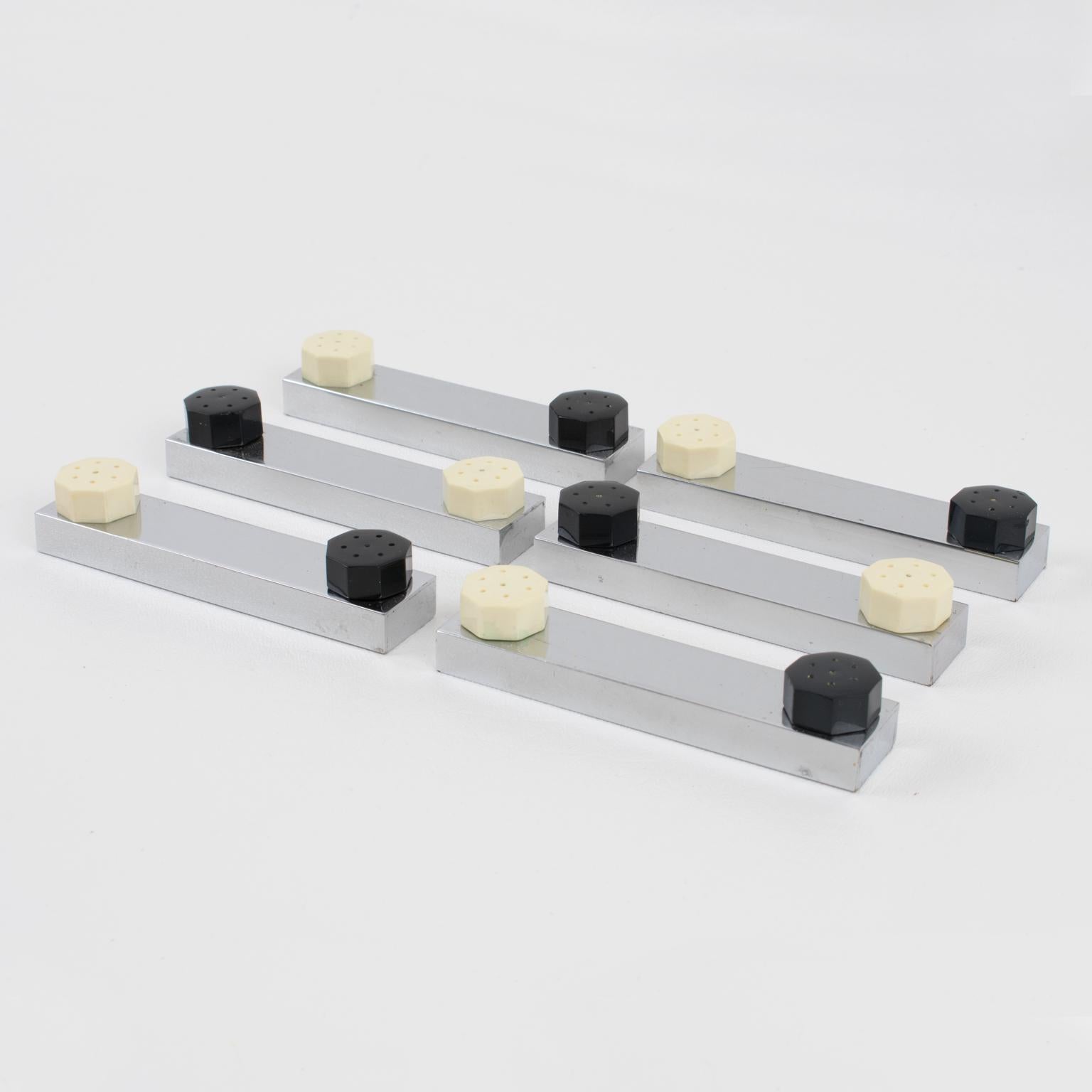This French Art Deco knife-rest or chopstick-rest ensemble is still in its original box. The geometric shape features a chromed metal square stick shape with individual salt and pepper shaker inserts made in black and off-white Galalith. The