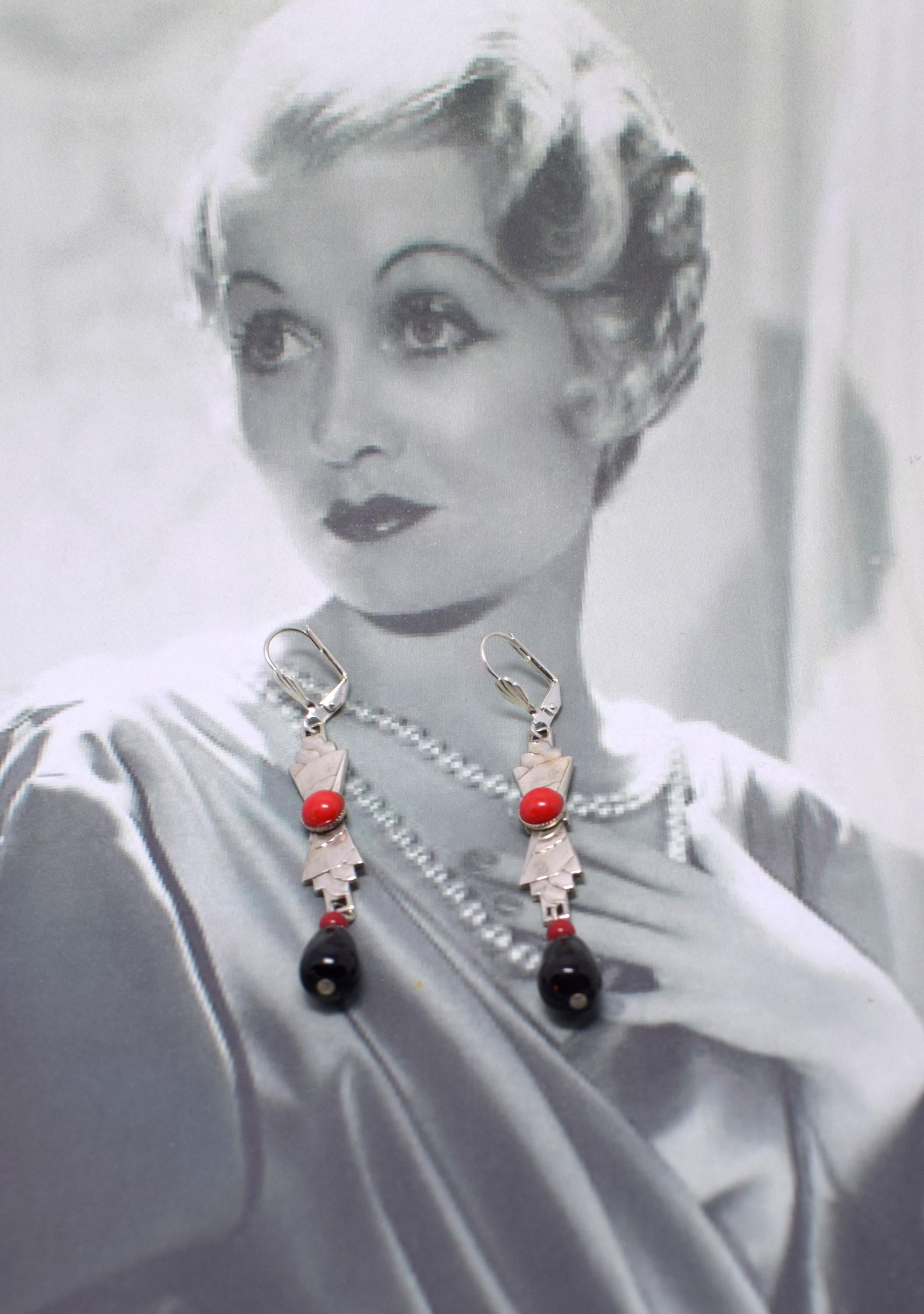 Beautiful piece of Art Deco jewellery dating to the 1930's. These earrings are an absolute delight and any lady of style will love them.  Made from black and cherry red glass with silver plate, embossed with a geometric patterning. The detailing and