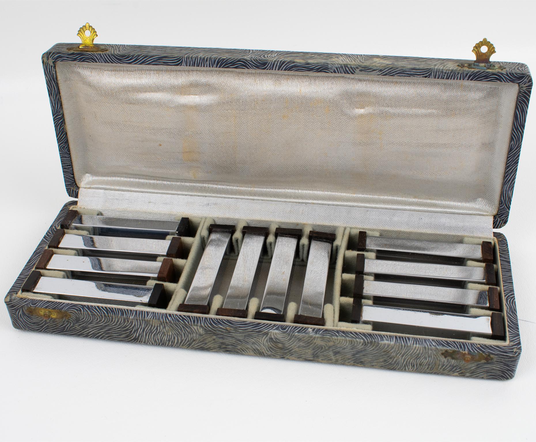 This lovely Art Deco set of twelve Macassar wood and chromed metal wood knife or chopstick rests was crafted in France in the 1930s. The tableware serving pieces feature a modernist shape with a square stick bar and geometric carved wood sides.