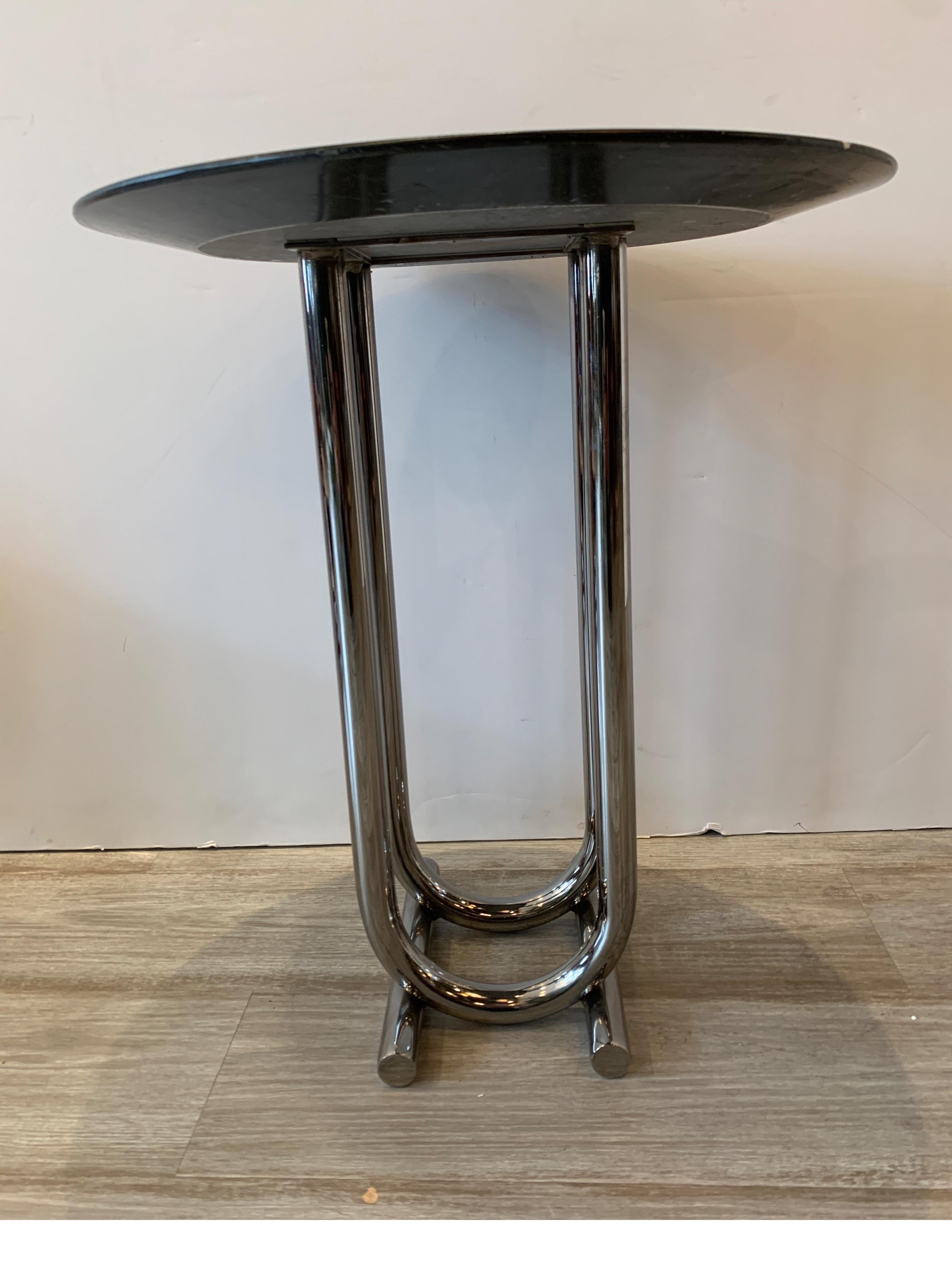 Chic marble and chrome Martini table circa 1940s in the manner of Joseph Hoffman. The mostly black honed marble with some white throughout resting on U-shaped sturdy metal tubing legs.