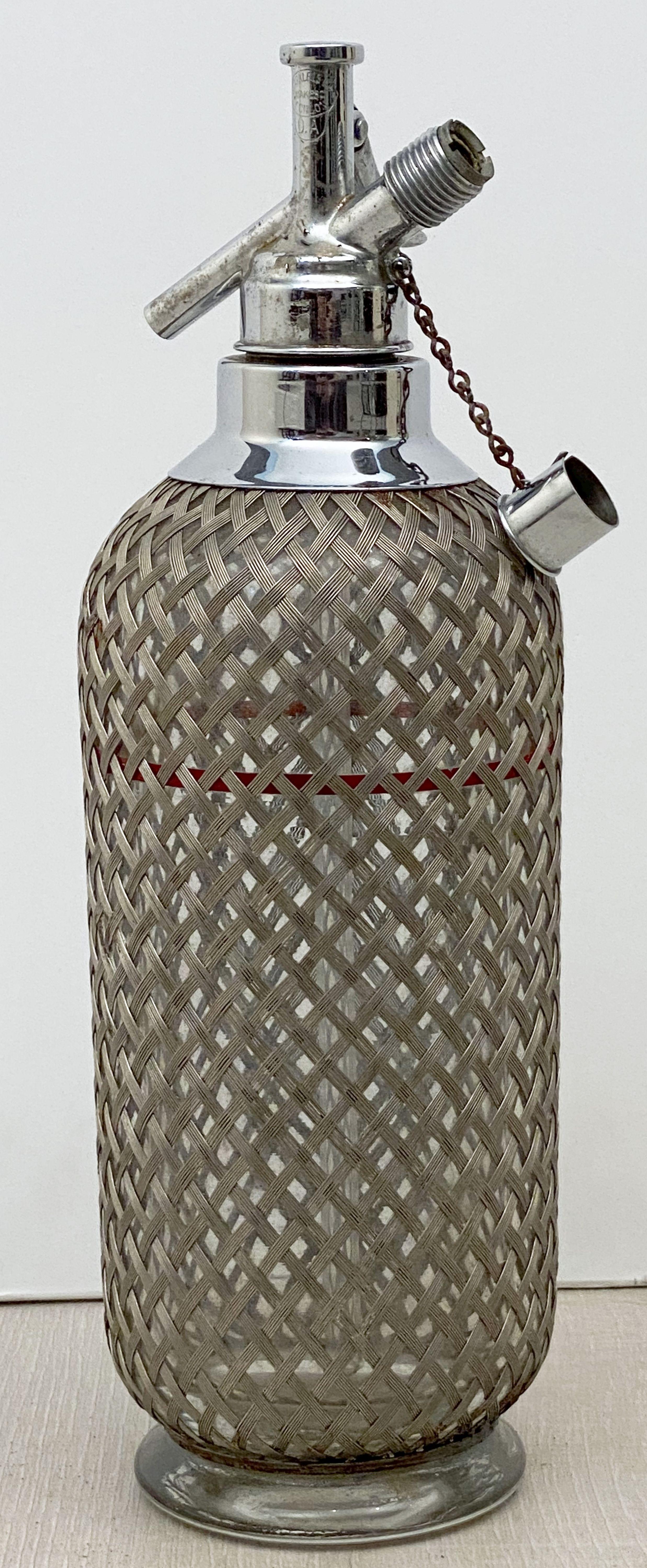 A fine English soda siphon (or syphon) from the Art Deco Era by the celebrated Sparklets of London, featuring a wire mesh over glass.

The first Sparklets syphon was made in 1896. As it contained water ‘gassed’ by the Sparklet bulb, it was covered