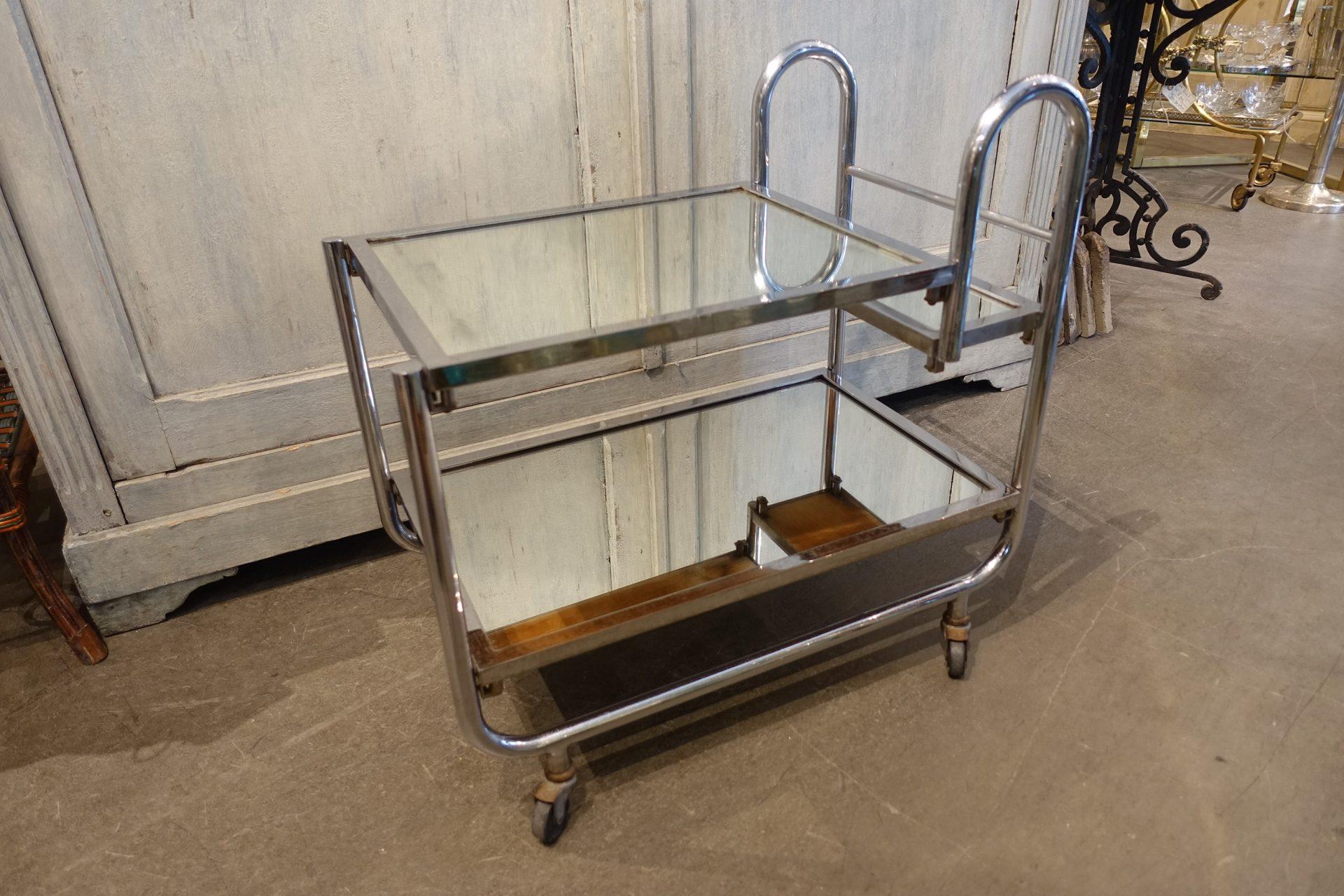 Fabulous French Art Deco serving trolley / bar cart, in a beautiful chrome design with patinated mirror glass plates.

Designed by French designer Jacques Adnet (1900-84), back in the 1930s. He largely applied the functionalist principles of “Less
