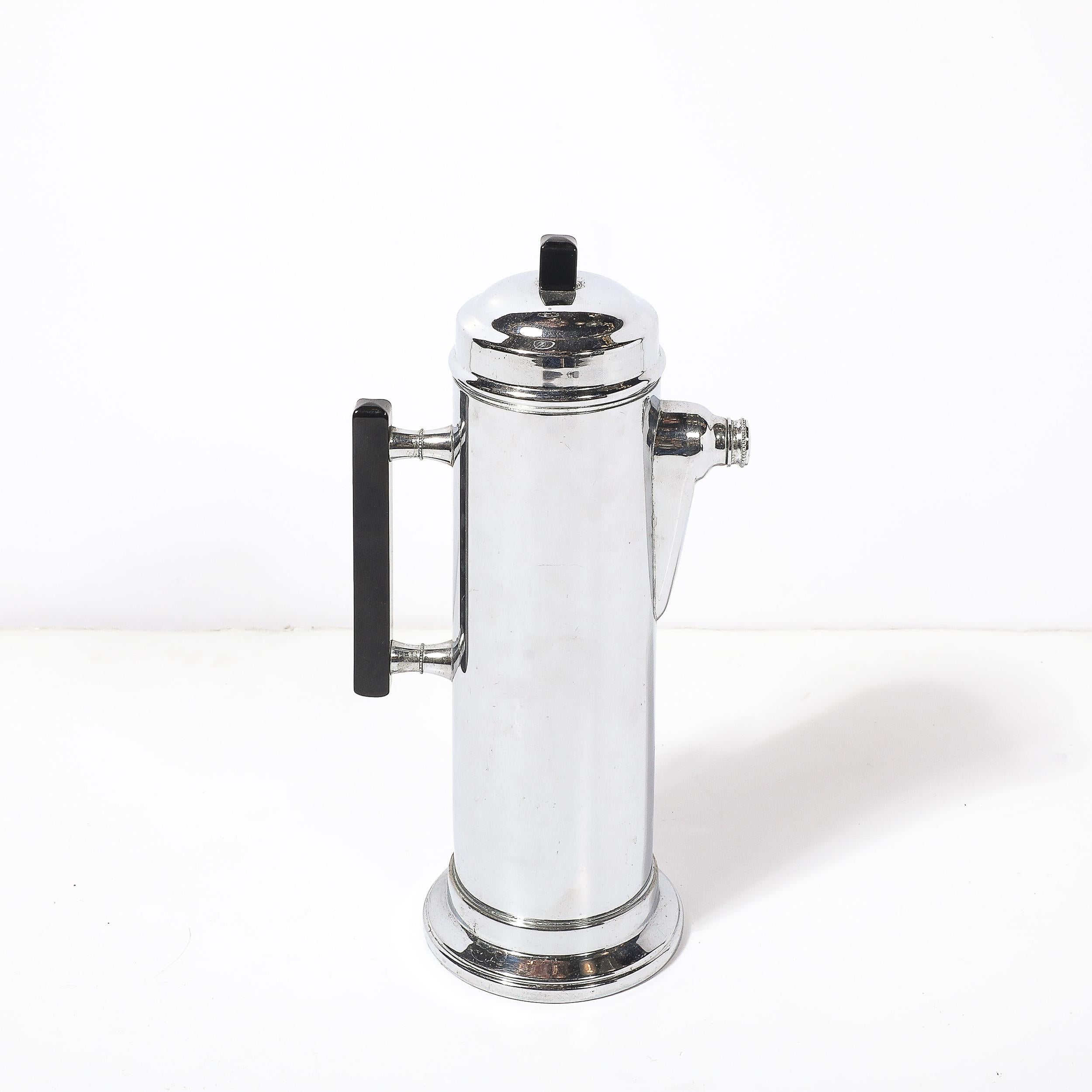 Dieser atemberaubende Art-Déco-Cocktailshaker, der um 1935 in Amerika hergestellt wurde, ist ein Beispiel für die elegante und moderne Ästhetik des Maschinenzeitalters. Mit seinem polierten Chromgehäuse und den auffälligen schwarzen Bakelit-Akzenten