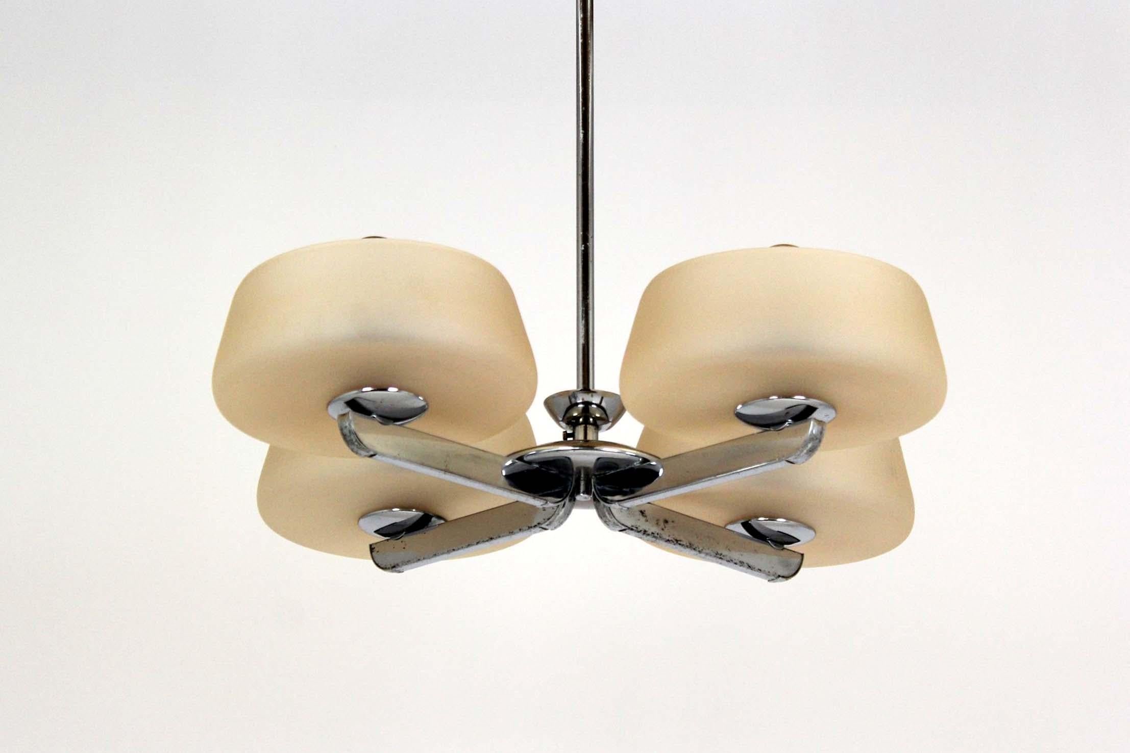 A striking four-arm chandelier designed and manufactured by ESC in former Czechoslovakia, most likely dating from the 1930s–1950s. Featuring a chromed metal frame with visible patina and oxidation spots, it is completed by four elegantly curved