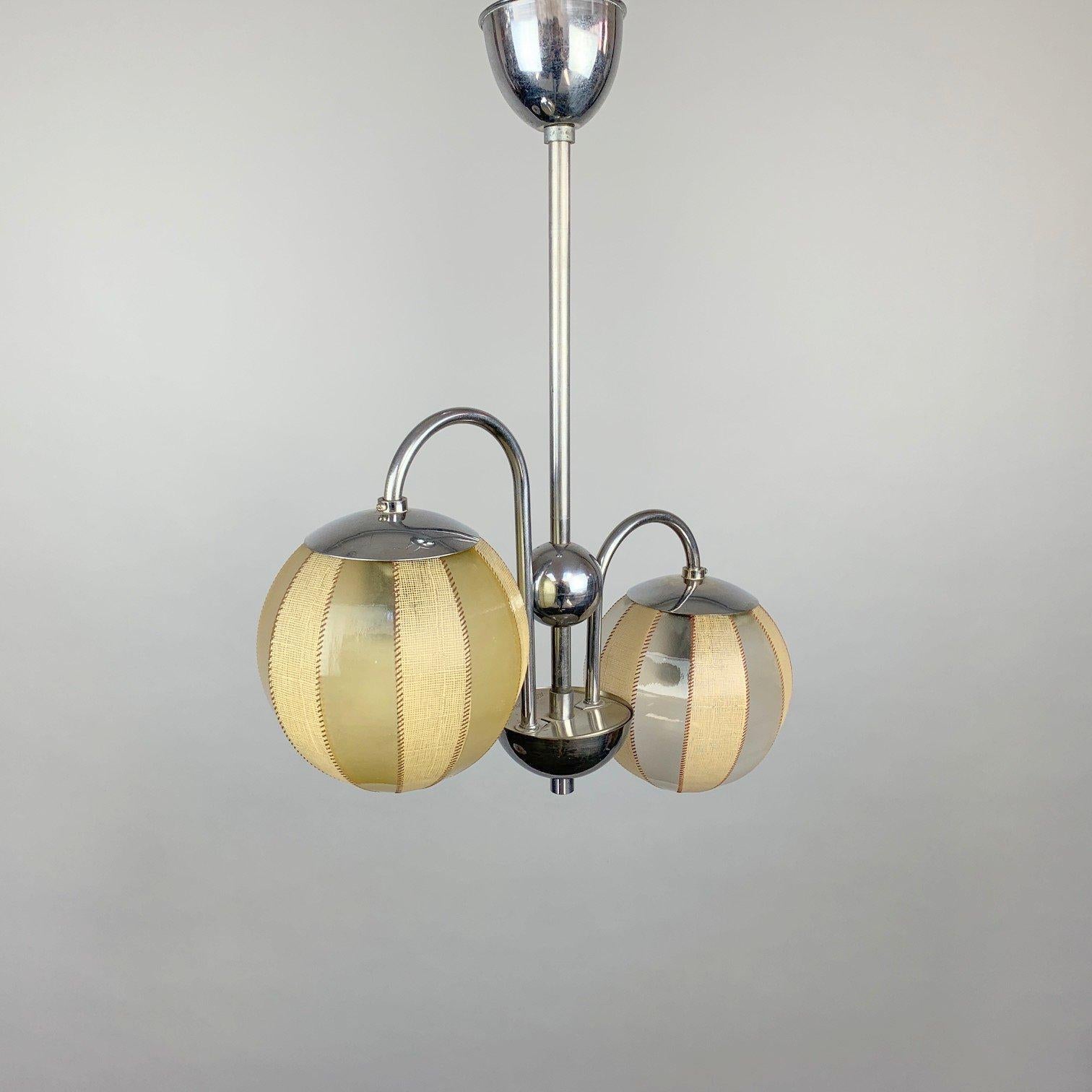 Beautiful two-arm art deco chandelier, made of chrome and plastic in former Czechoslovakia by Napako in the 1930's. In very good vintage condition. Original wiring, fully functional. 
Bulbs: 2 x E27 or E26.