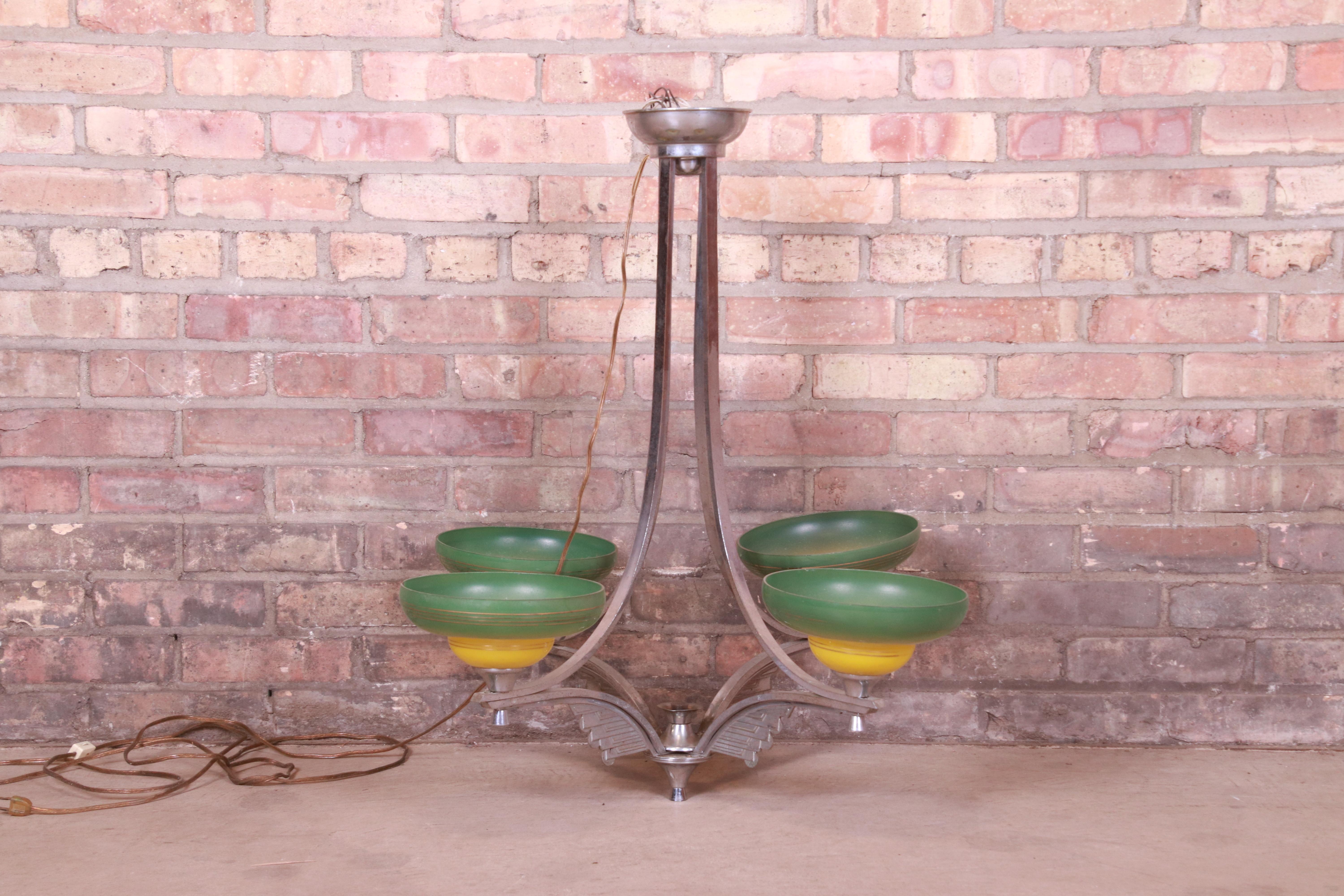 A gorgeous Art Deco period chandlier

USA, Circa 1930s

Chrome, with gorgeous green and yellow painted blown glass shades.

Measures: 29.5