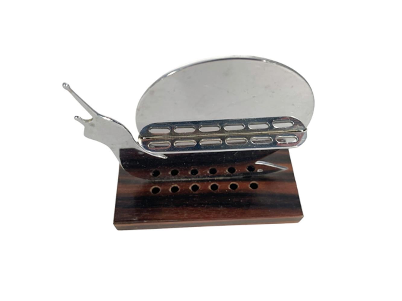 French Art Deco cocktail pick set with a flat, chrome snail on a wood base, the snail with a pierced shelf on each side holding 6 snail topped picks each.