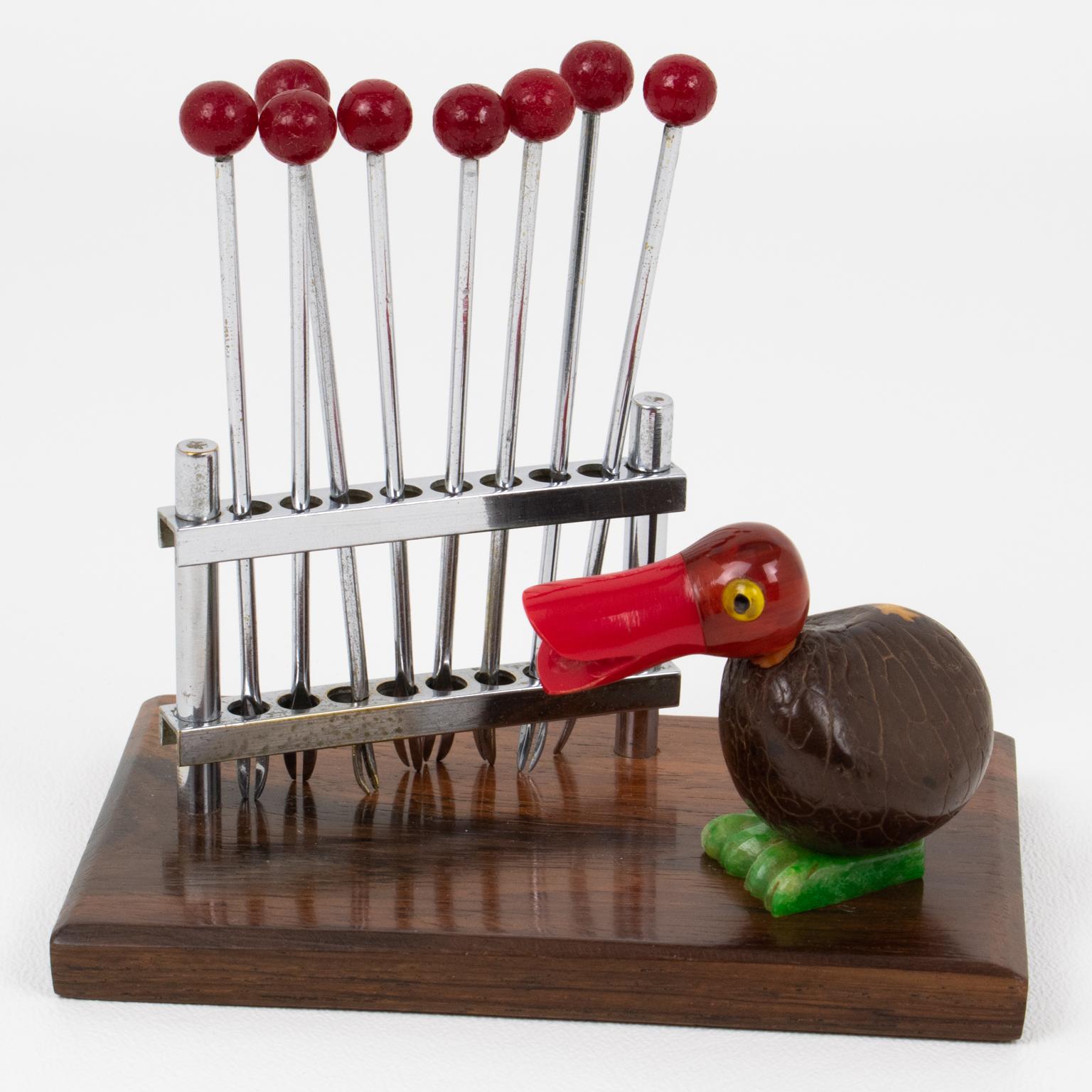 This lovely barware bar set cocktail pick was hand-crafted in France circa 1930. The bar set features a Bakelite and Corozo nut bird facing a chromed metal fence turned into a fork holder. The metal fence holds eight metal cocktail forks with red