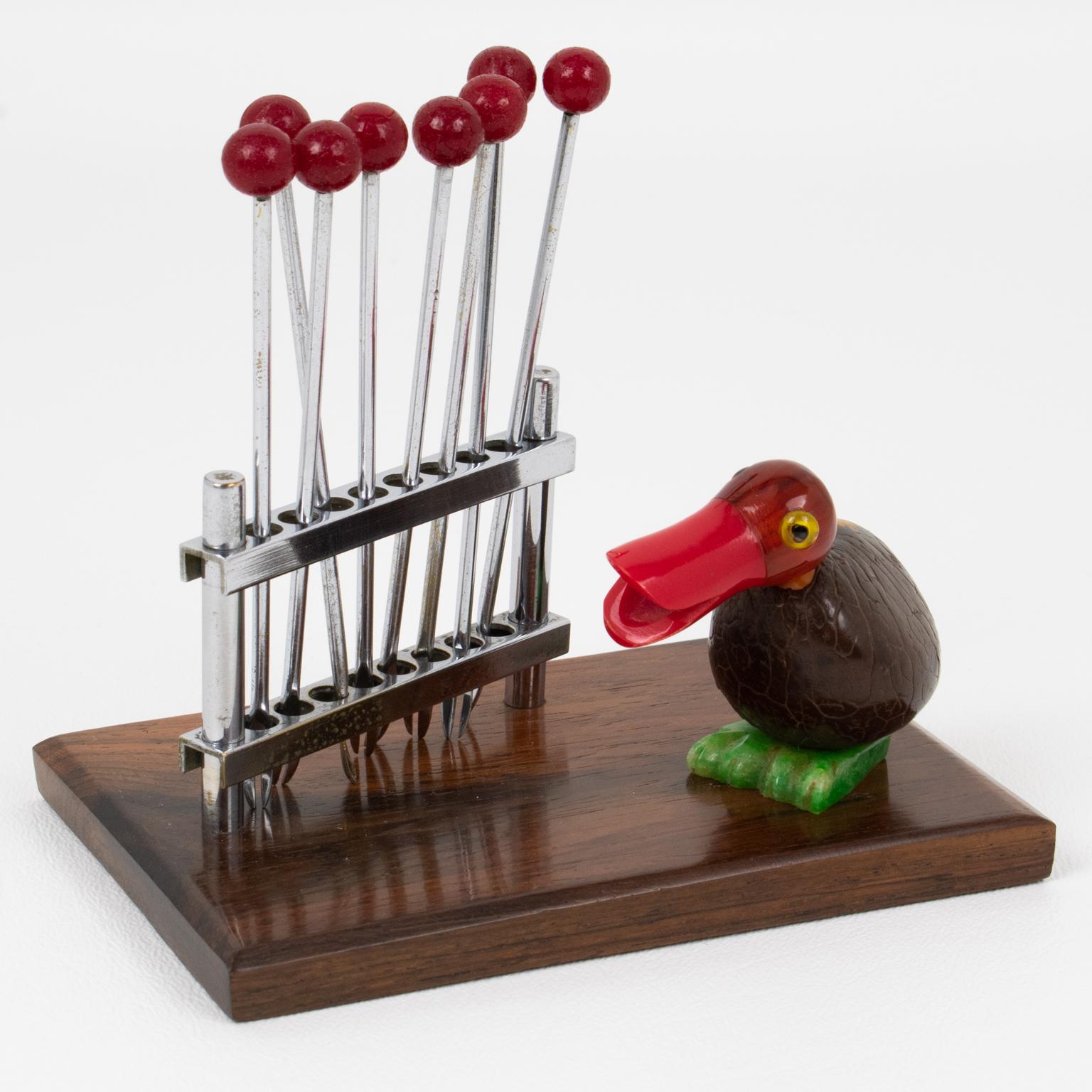 This lovely barware bar set cocktail pick was hand-crafted in France in the 1930s. The bar set features a Bakelite and Corozo nut bird facing a chromed metal fence turned into a fork holder. The metal fence holds eight metal cocktail forks with red